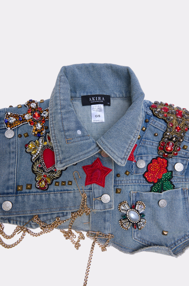 The STYLE ME UP DENIM COLLAR is a blue denim jacket featuring a classic collar, "AKIRA" label, red and gold beadwork, embroidered patches, metallic studs, chains, and ornate embellishments on the shoulders and front.