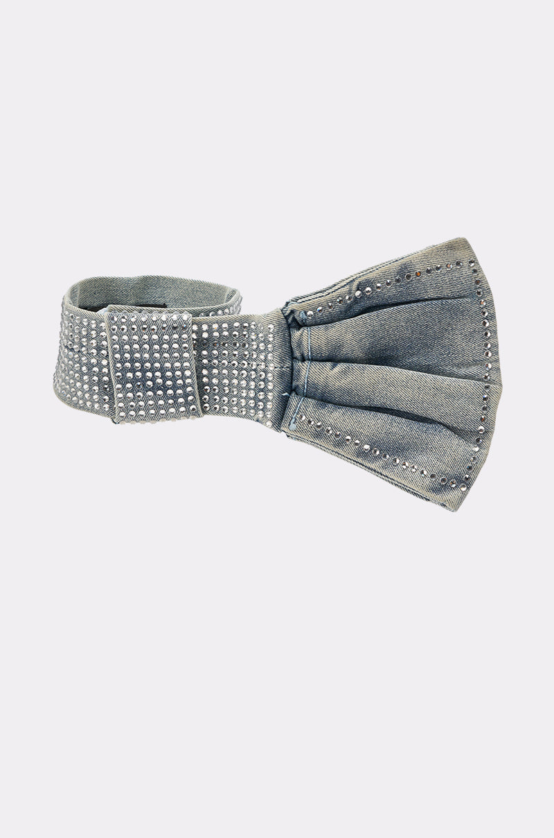 The WITH A BOW DENIM NECKLACE is a denim choker adorned with rows of shiny silver studs, shown against a plain light background. 2