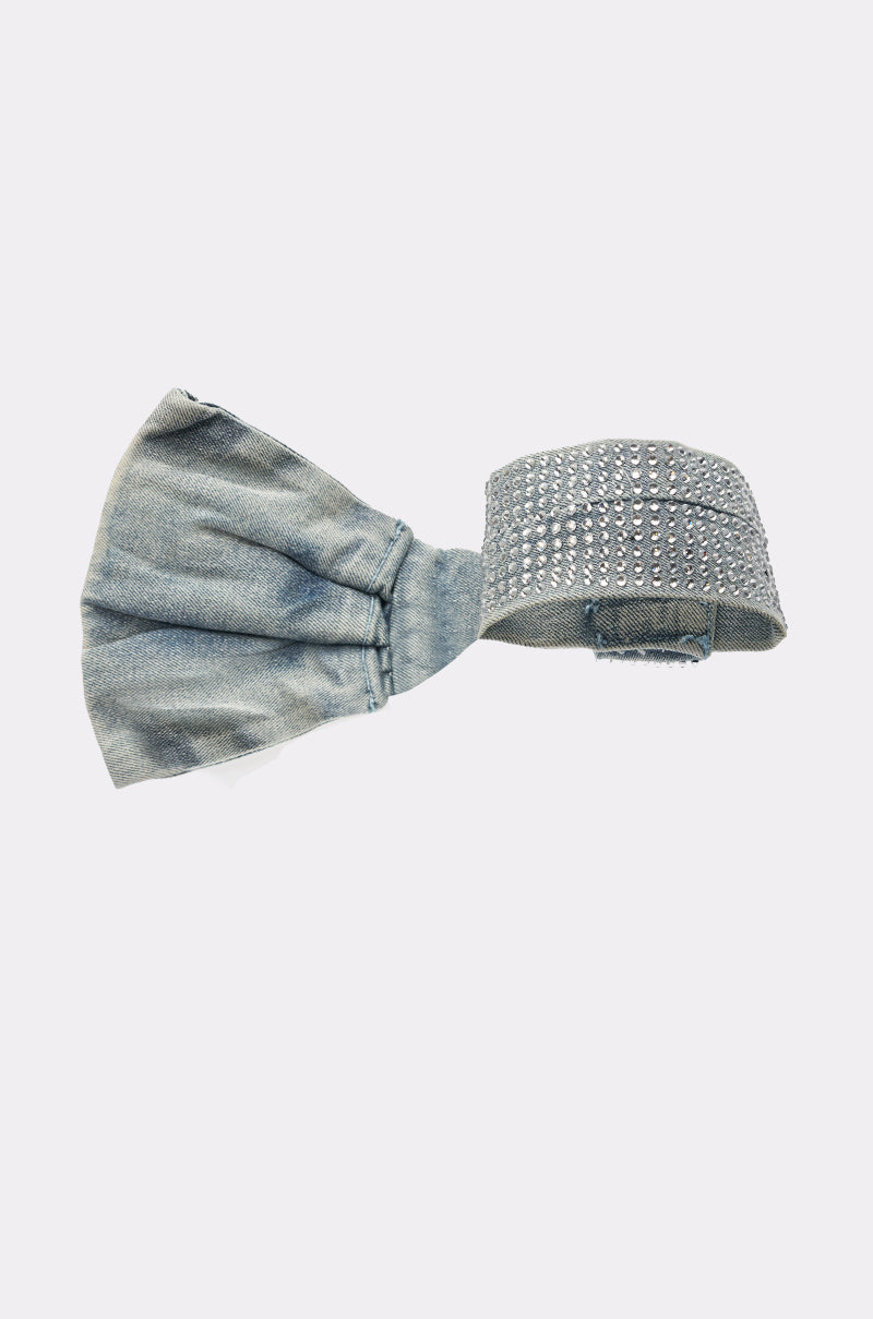 The WITH A BOW DENIM NECKLACE features blue denim and rows of sparkling rhinestones, evoking the look of a rhinestone choker, and is displayed against a light gray background. 4
