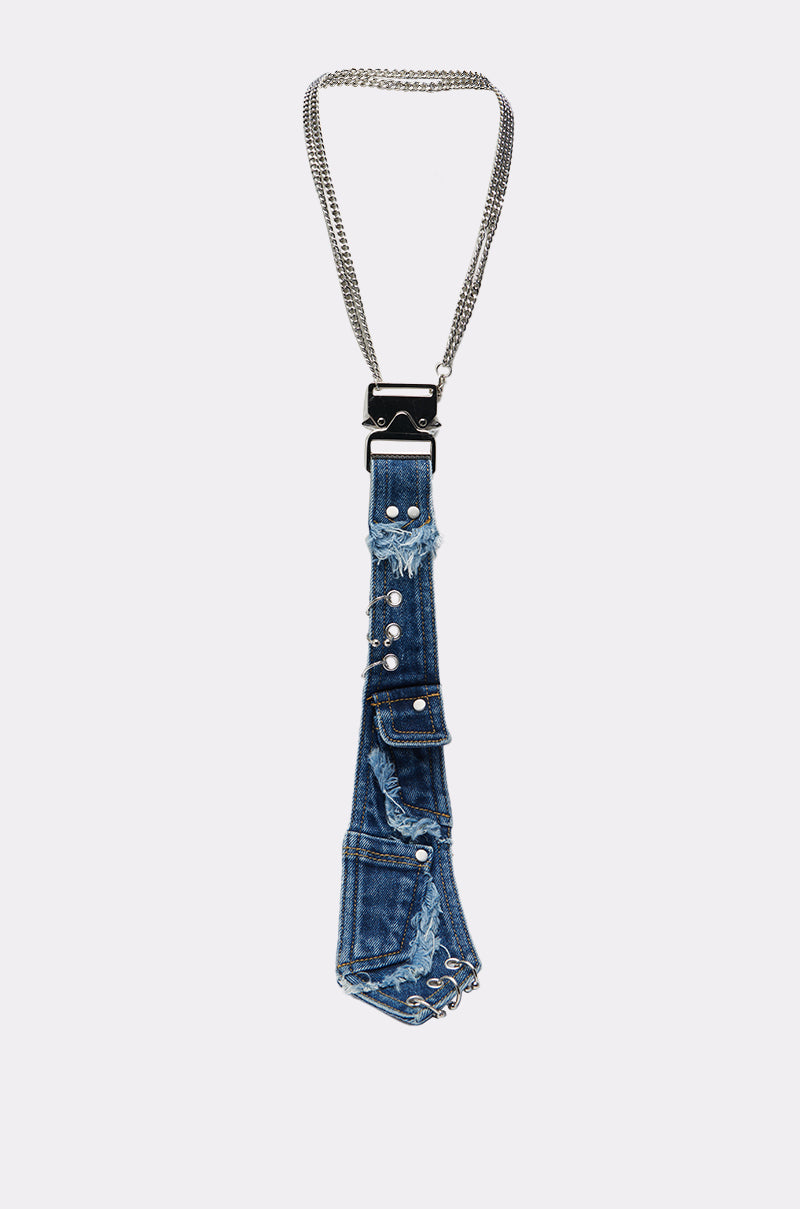 The MIXED FEELINGS DENIM TIE features blue denim, distressed details, silver hardware studs, small pockets, and a double silver chain neck strap for a punk-princess vibe, shown against a plain white background.