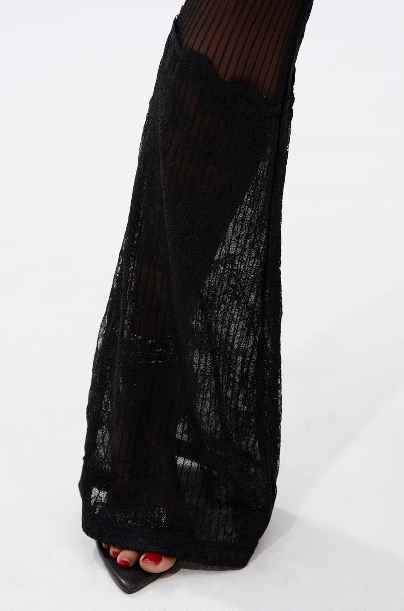 A close-up of a foot in RELAX THOSE EYES LACE LEGGING, featuring sheer black fabric with vertical stripes over black open-toe shoes. Red toenails are visible through the leggings, set against a plain white background.