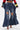 Wearing SPARKLE QUEEN WIDE-LEG DENIM with rhinestone accents, large front rips, and bold side panels, styled with heeled sandals and a cropped long-sleeve top for a striking statement look.