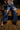 Wearing SPARKLE QUEEN WIDE-LEG DENIM and clear heels, a person poses by a pool table in a dimly lit room with wooden floors and brick walls.