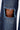 Close-up of SPARKLE QUEEN WIDE-LEG DENIM: blue rhinestone pants with silver embellishments, highlighted by a large frayed knee rip exposing skin.