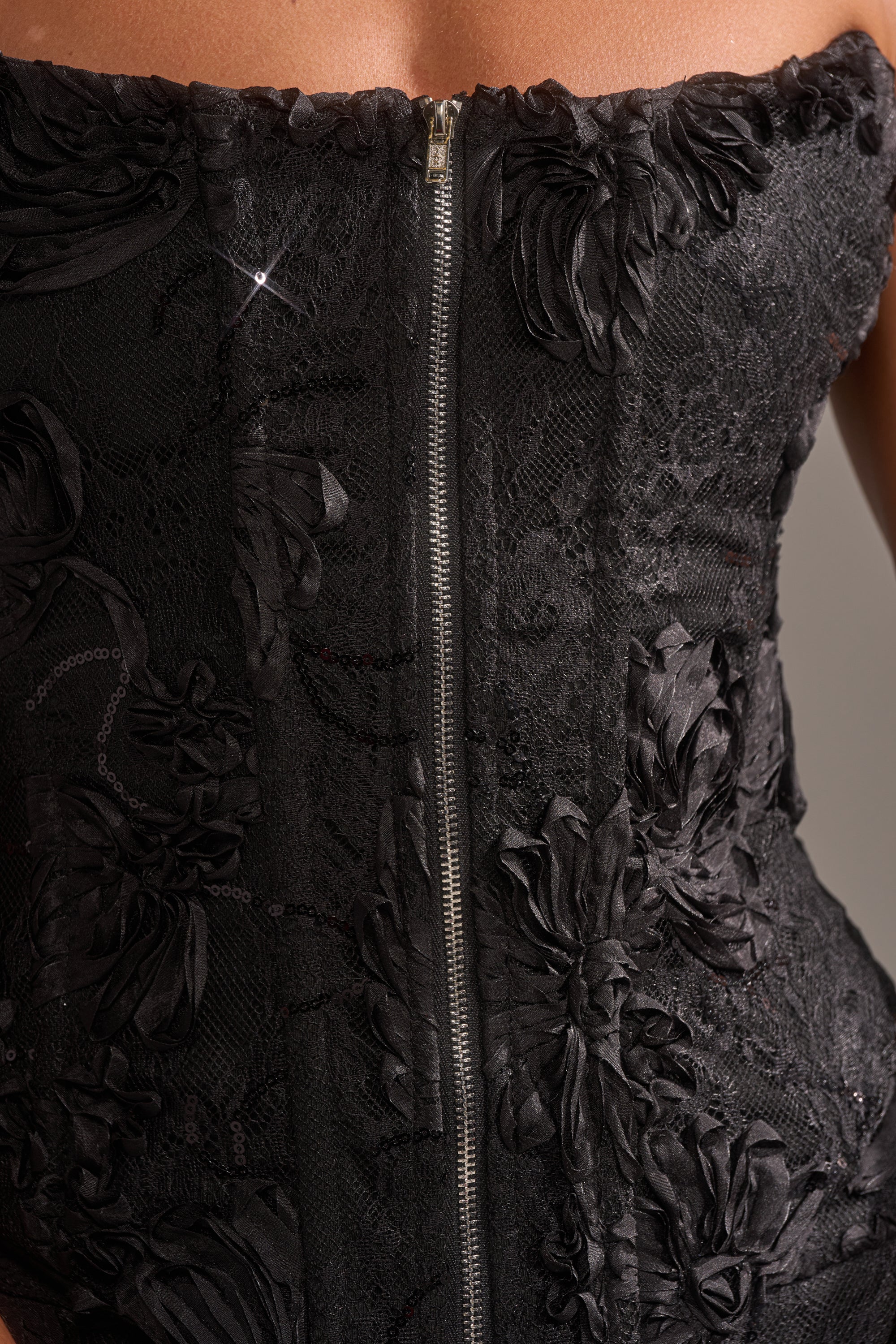 Close-up of the LET IT GO LACE CORSET, a black strapless dress with floral mesh lace patterns, center zipper, and textured fabric details.