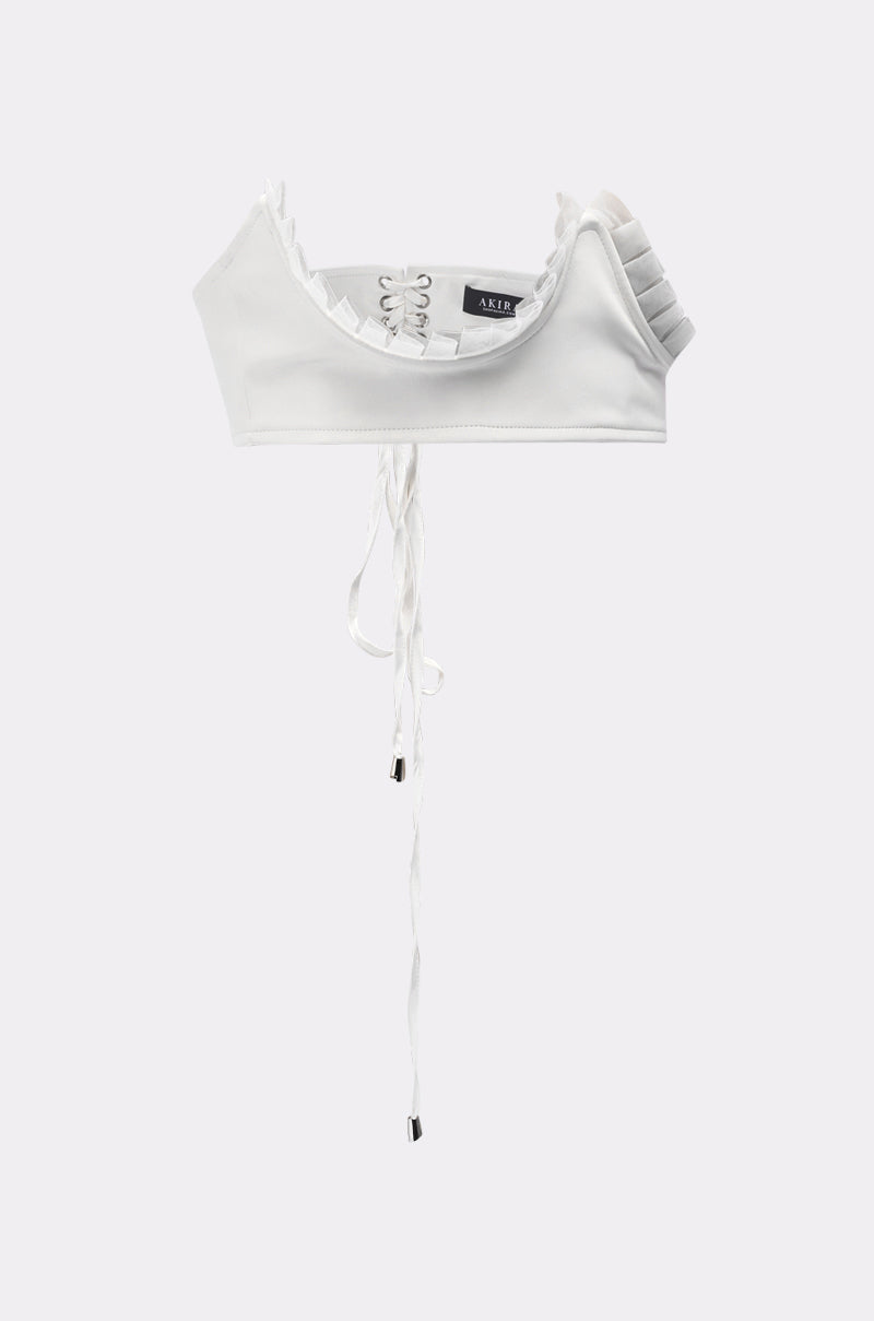 The RUFFLE ME TO IT UNDERBUST BELT is paired with a white cropped top featuring a lace-up front, pleated one-shoulder detail, and long ties, displayed on a plain light gray background. 3