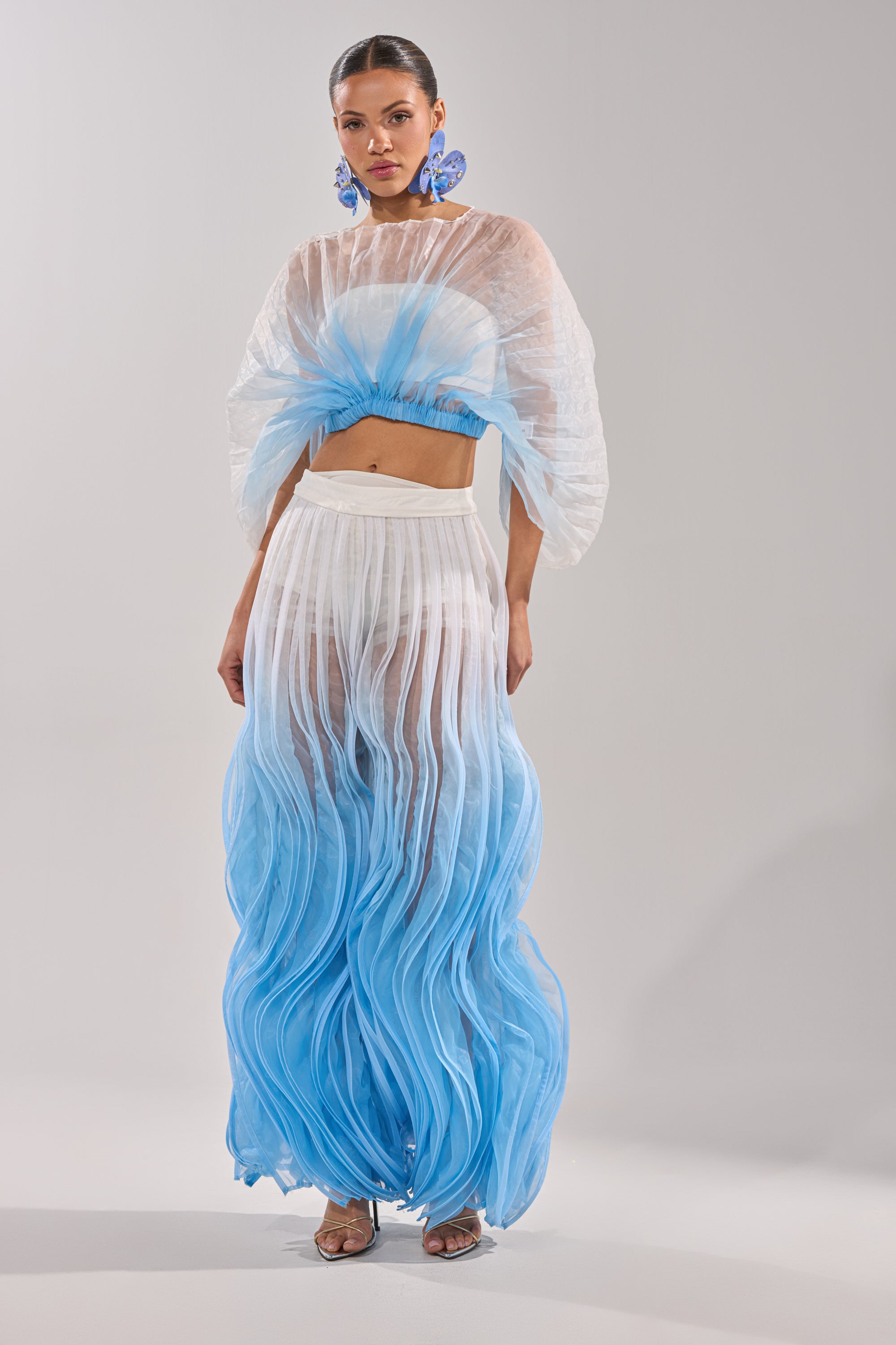 A woman in the IN THE SKY PALAZZO PANT and a transparent outfit. 6