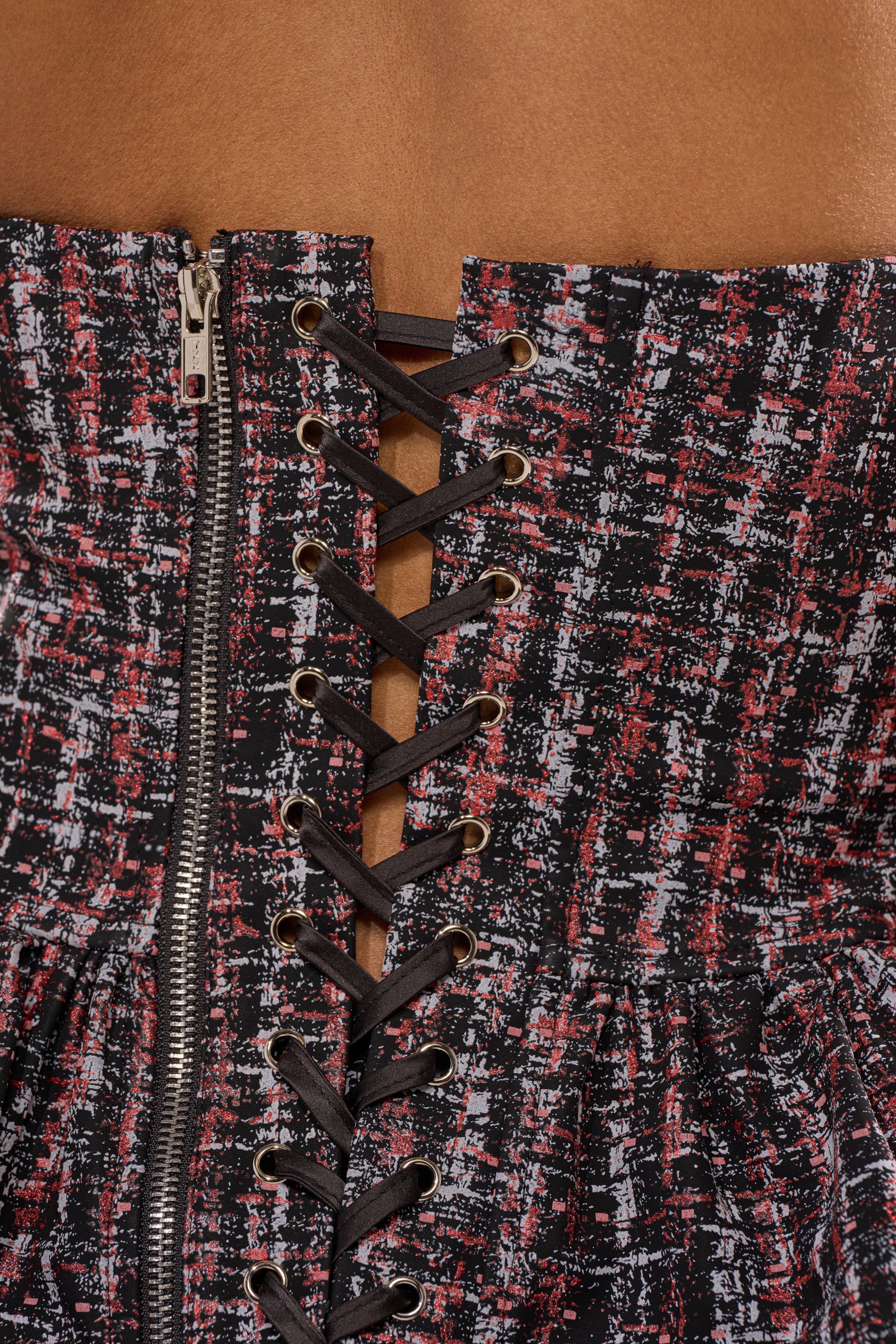 Pair the WORK IT FAUX LEATHER PLAID TROUSER with a textured corset featuring black laces, metal eyelets, a silver side zipper, and a mix of red, white, and black fabric for a bold look. 6