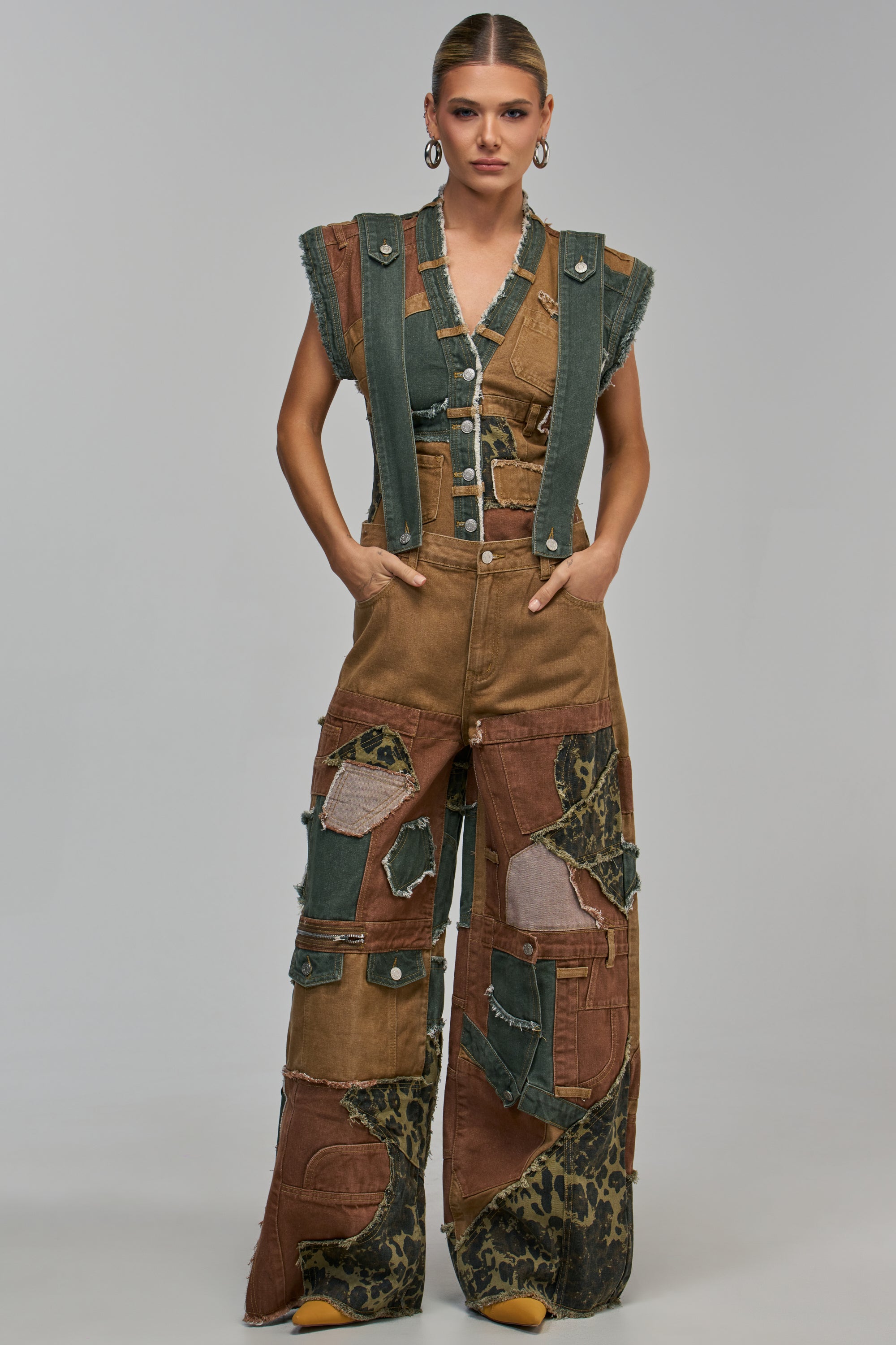 LAYLA PATCHWORK DENIM PANT featuring wide-leg, patchwork denim cargo overalls with brown and green fabric panels, some with animal print accents and frayed edges.