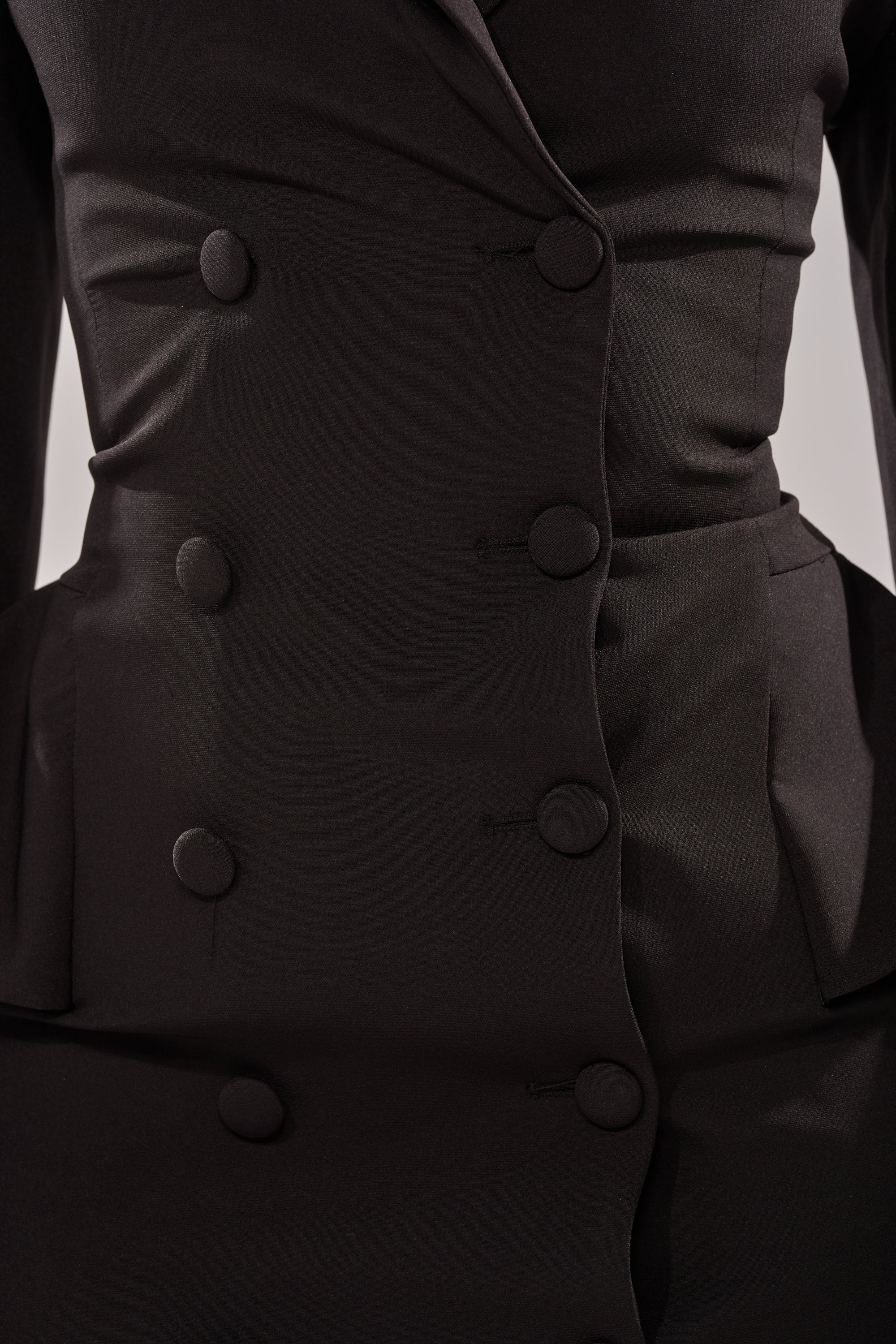 Close-up of the KIMMY BLAZER MAXI DRESS, a tailored black double-breasted design with fabric-covered buttons, structured seams, and a fitted waist highlighting its sophisticated suiting fabric.