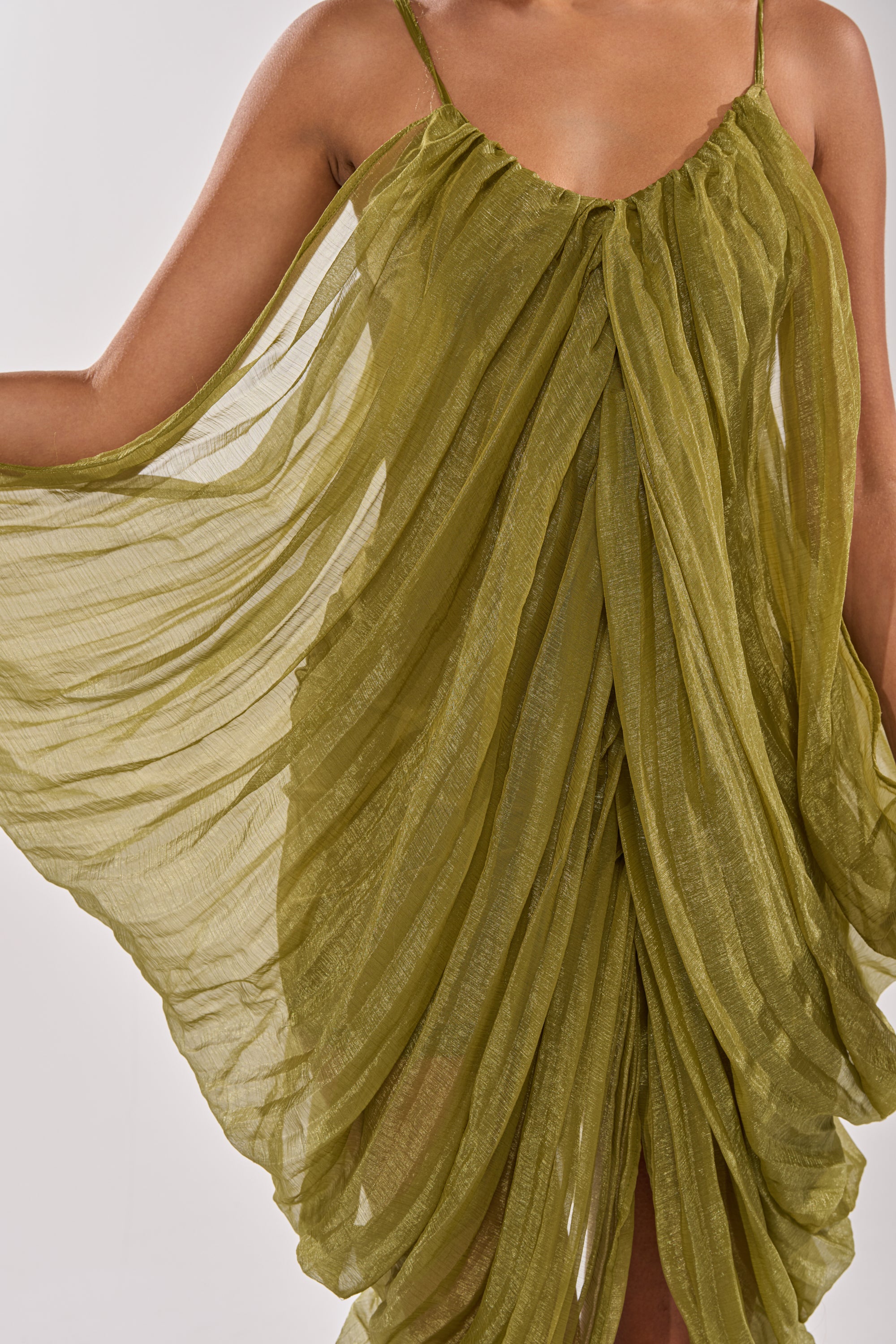 Wearing the VIVA LA VIDA MESH DRESS, a flowing olive midi with thin straps and pleated semi-sheer mesh, the look features airy texture and lightweight feel for a romantic touch shown from shoulders to knees. 7