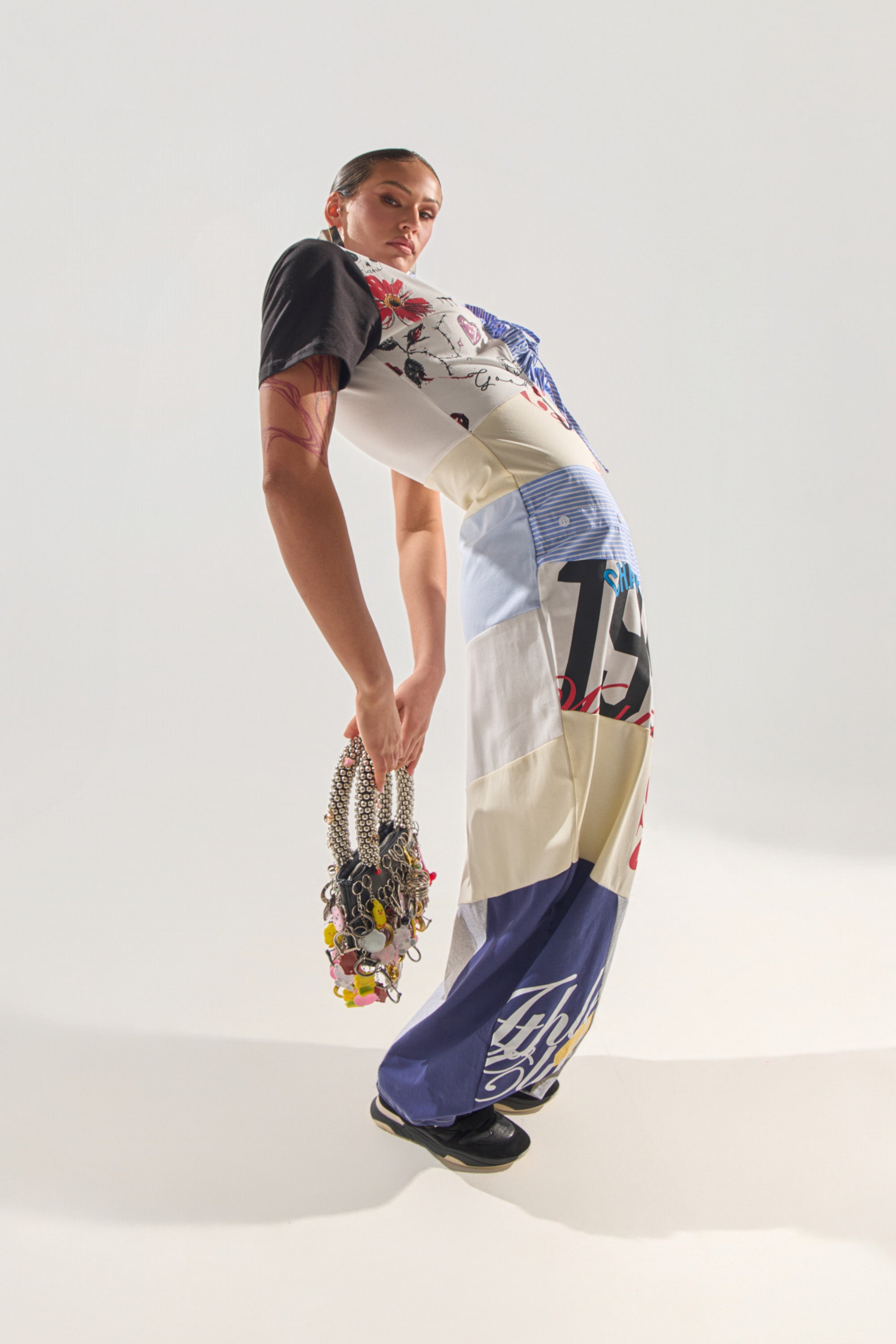 Wearing the SOMETHING DIFFERENT MAXI DRESS, a person strikes a dramatic, backward-leaning pose and holds a chunky chain accessory against a plain white background. 3
