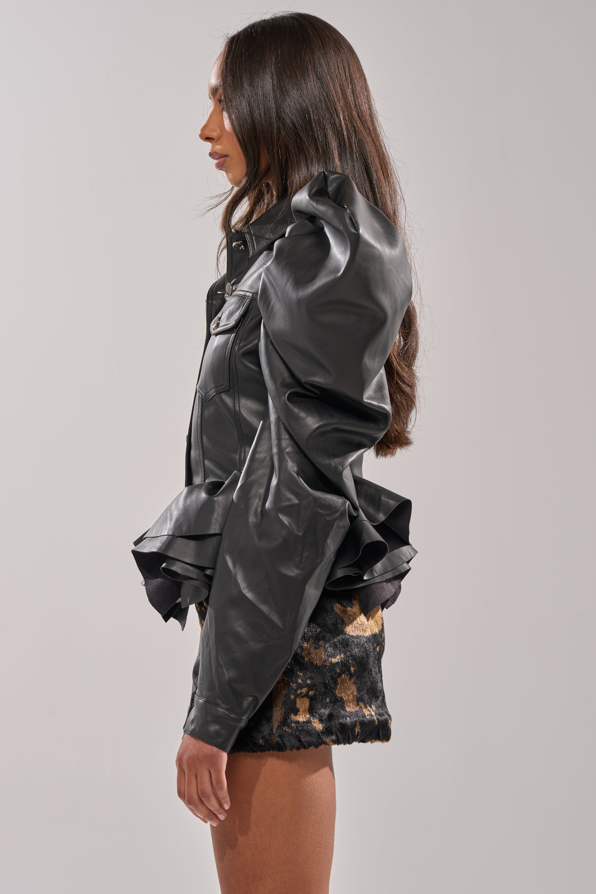 A woman exudes confidence in the NIGHT MOVES FAUX LEATHER JACKET, making a bold statement with this standout outerwear. 3