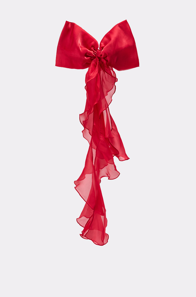 The HEY DOLL CHIFFON HAIR BOW is a large red satin bow with long, sheer chiffon tails—perfect as an oversized hair accessory—shown on a plain light background. 2