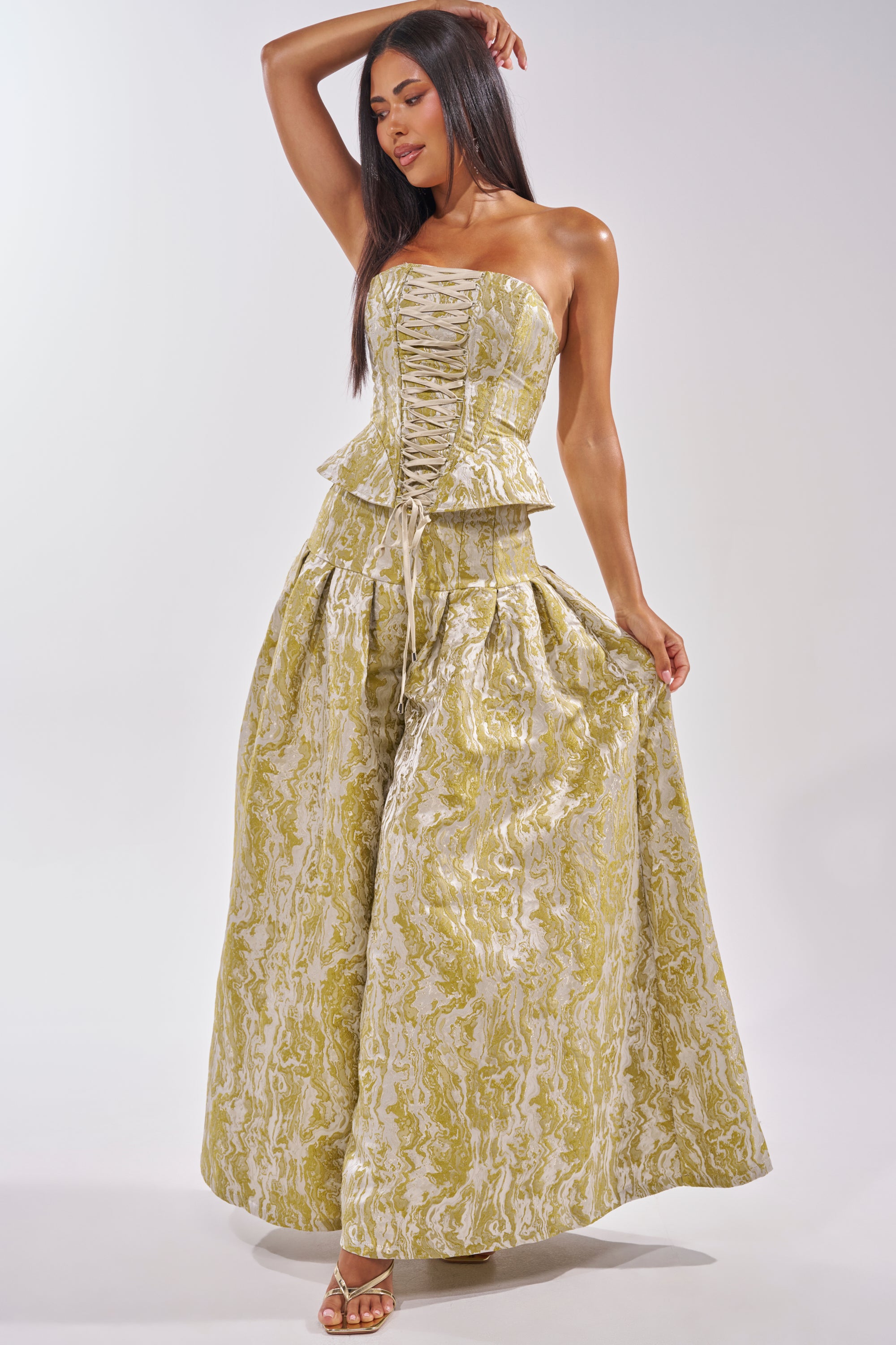 A woman models the GET IT FLORAL TROUSER, paired with a strapless, lace-up corset top featuring peplum detail and styled with heeled sandals—an eye-catching look for brunch or wedding guest events. 7