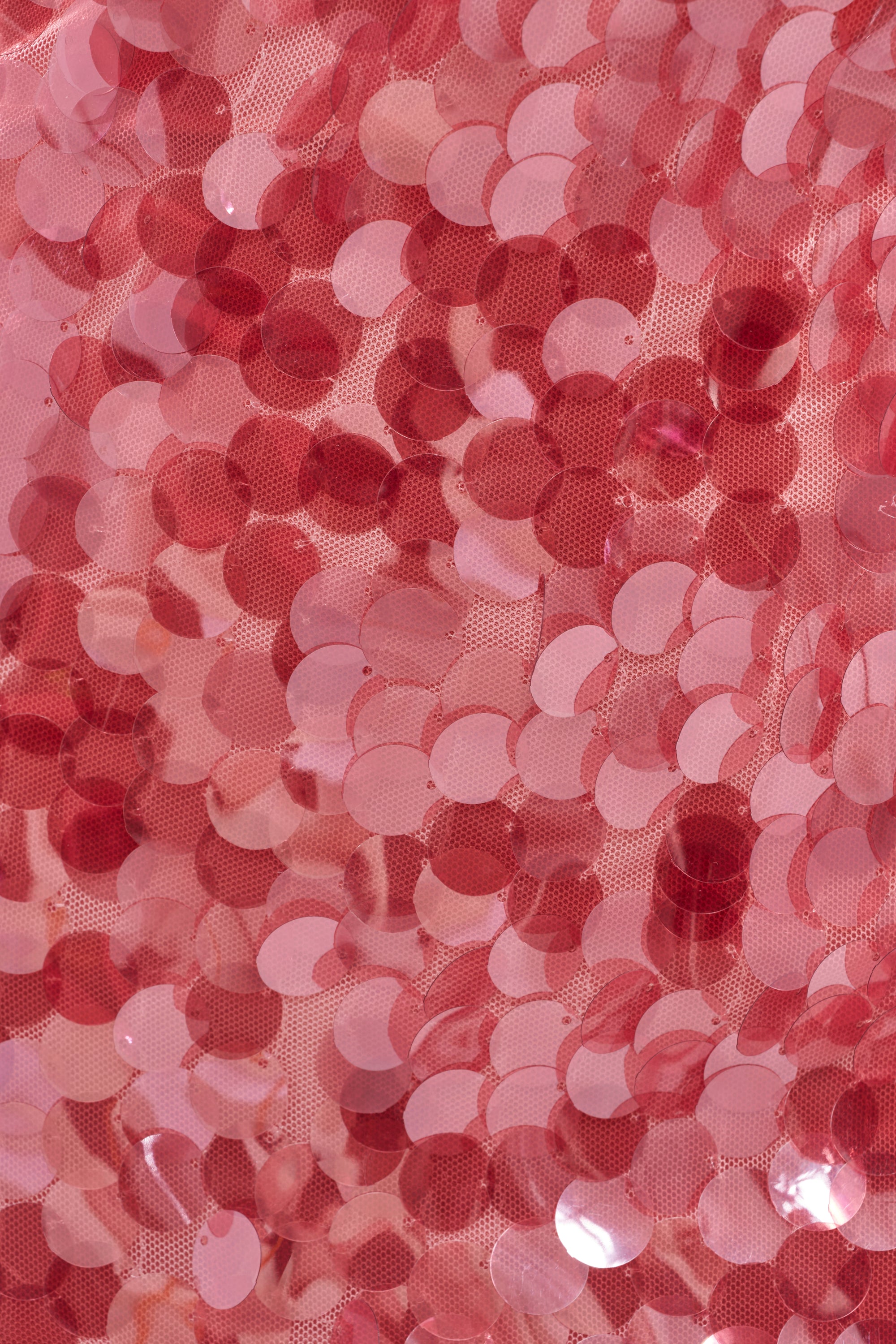 Close-up of shiny, round pink sequins overlapping on fabric, creating a sparkling texture—ideal for the JUST A PHASE SEQUIN MINI DRESS IN PINK or any dazzling party look. 8
