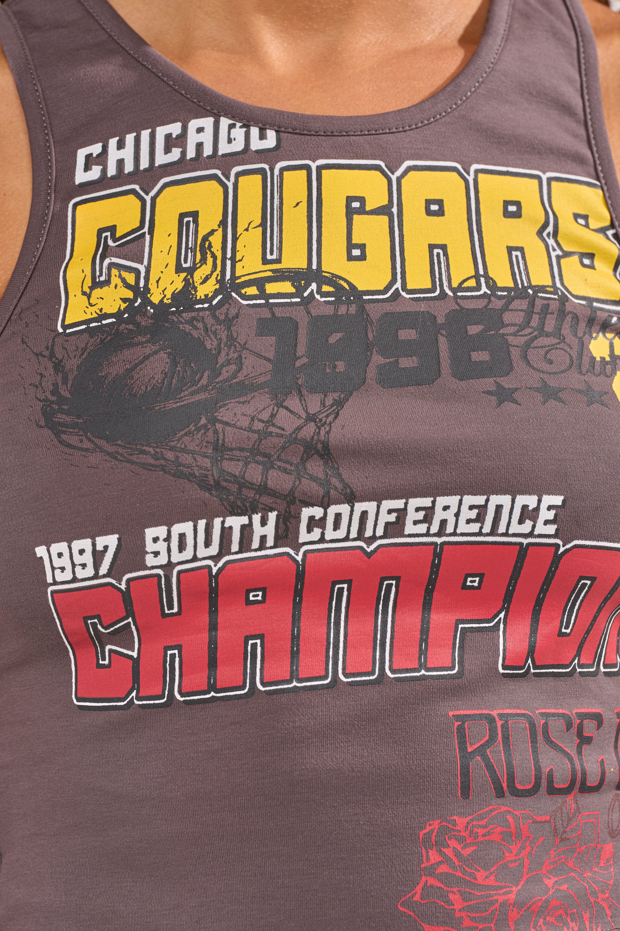 Close-up of the BIG WINNER GRAPHIC TANK—a grey cropped tank featuring bold "Chicago Cougars 1998, 1997 South Conference Champion" text, a red rose graphic, and faded basketball hoop design for sporty courtside style. 6