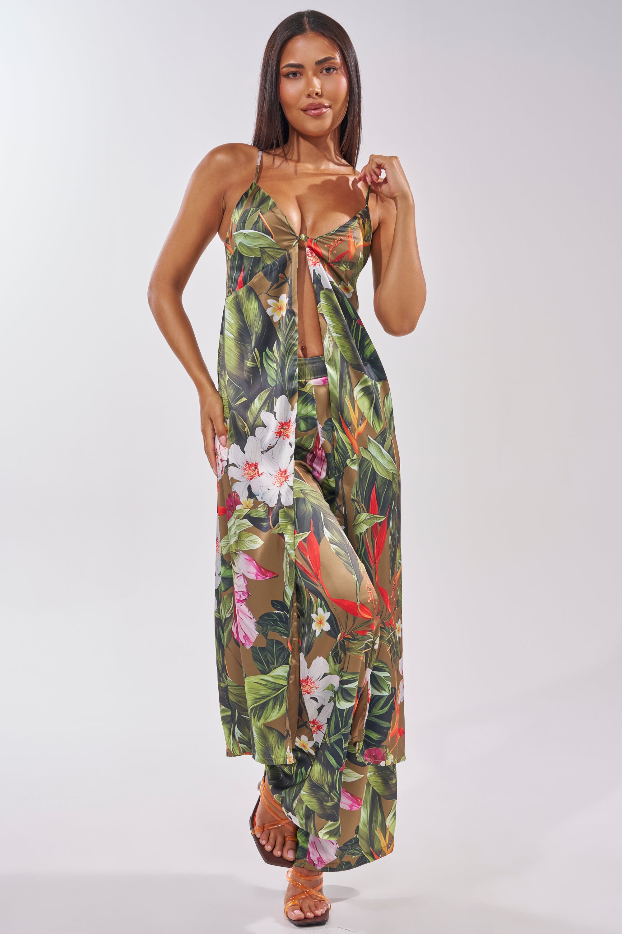 A woman models the INTO THE WILD FLORAL TROUSER with a matching sheer cover-up and strappy sandals, set against a plain light background. 6
