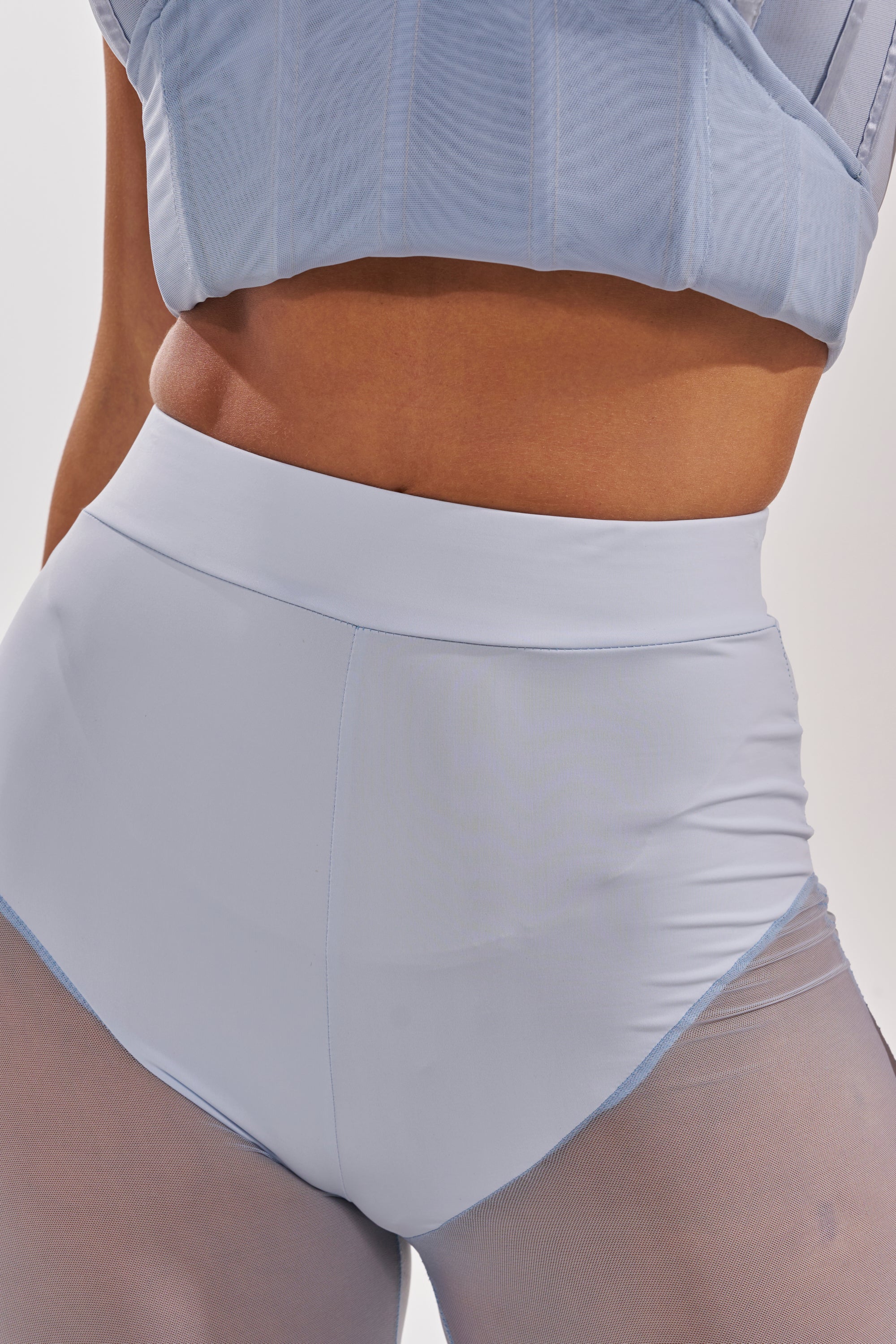 A person wears the FEELING BLUE MESH FLARE PANT, creating a mermaid-inspired look that highlights the midsection and upper thighs against a plain background. 10