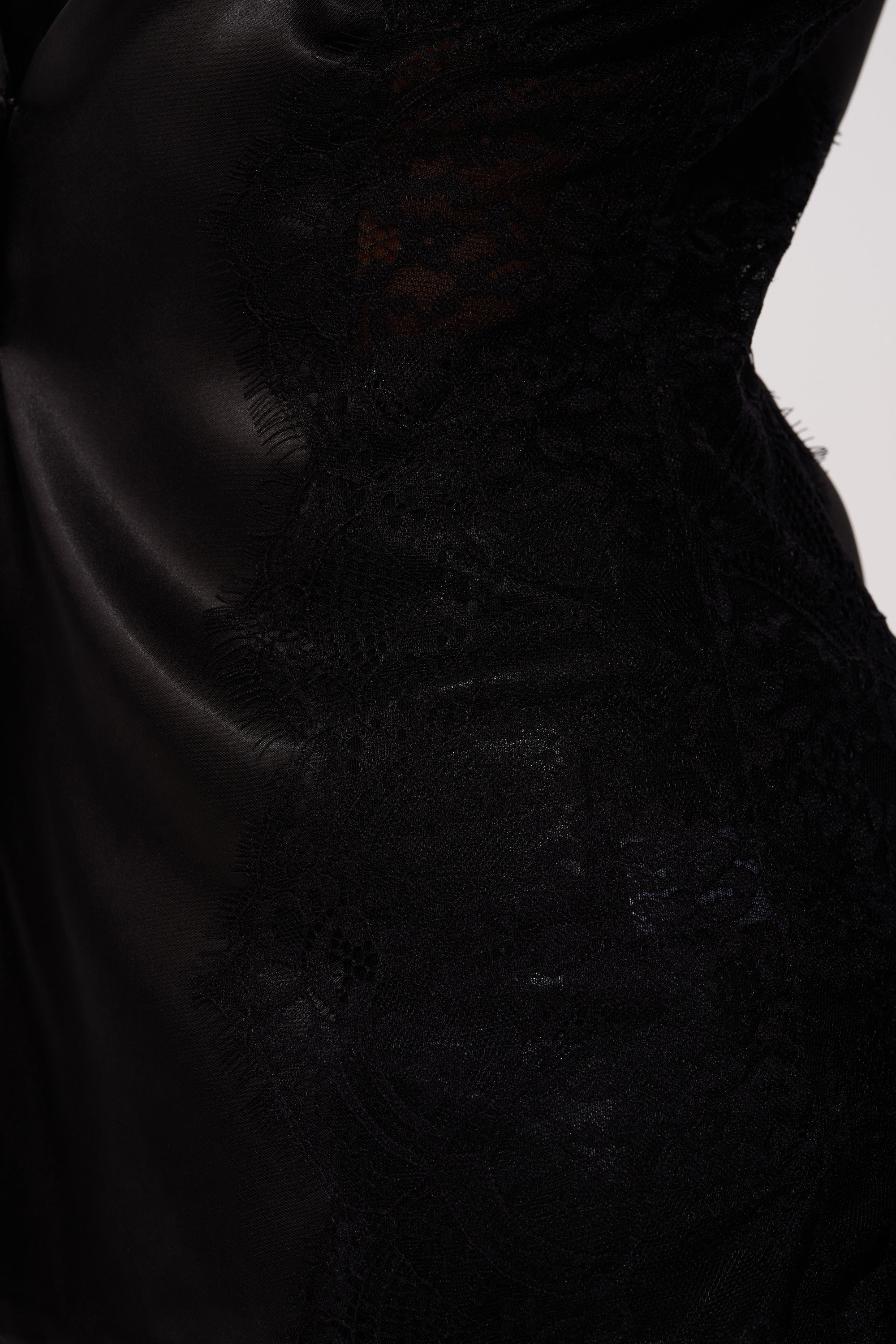 Close-up of the AU CONTRAIRE LACE SATIN BLAZER, showcasing its black floral lace sleeves and smooth, shiny satin fabric with elegant highlights and shadows. 10