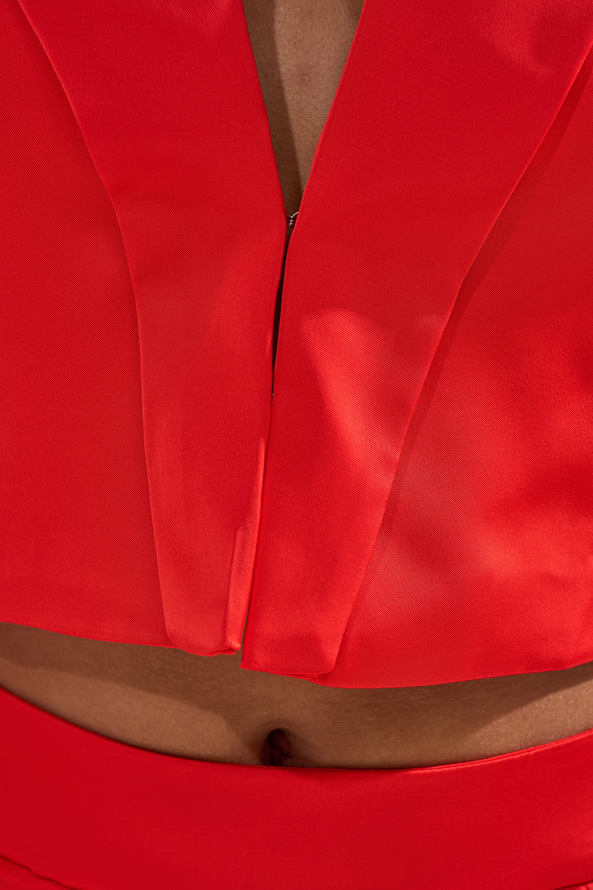 Close-up of a person modeling the RED HOT CROPPED SATIN BLAZER, highlighting the cropped fit and matching waistband that reveals part of their midriff and navel. 5