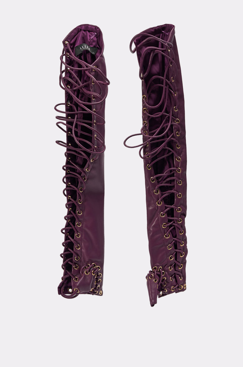 A pair of tall, purple lace-up boots with gold eyelets and open panels, shown upright against a plain light background—perfectly paired with WHAT THE HELLY GLOVES for a bold, coordinated look. 5