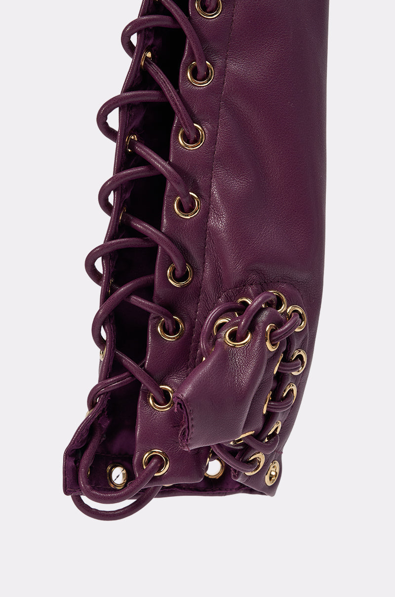 Close-up of WHAT THE HELLY GLOVES: purple faux leather lace-up gloves with gold eyelets and purple crisscross laces, showcasing detailed stitching and a rich texture. 7