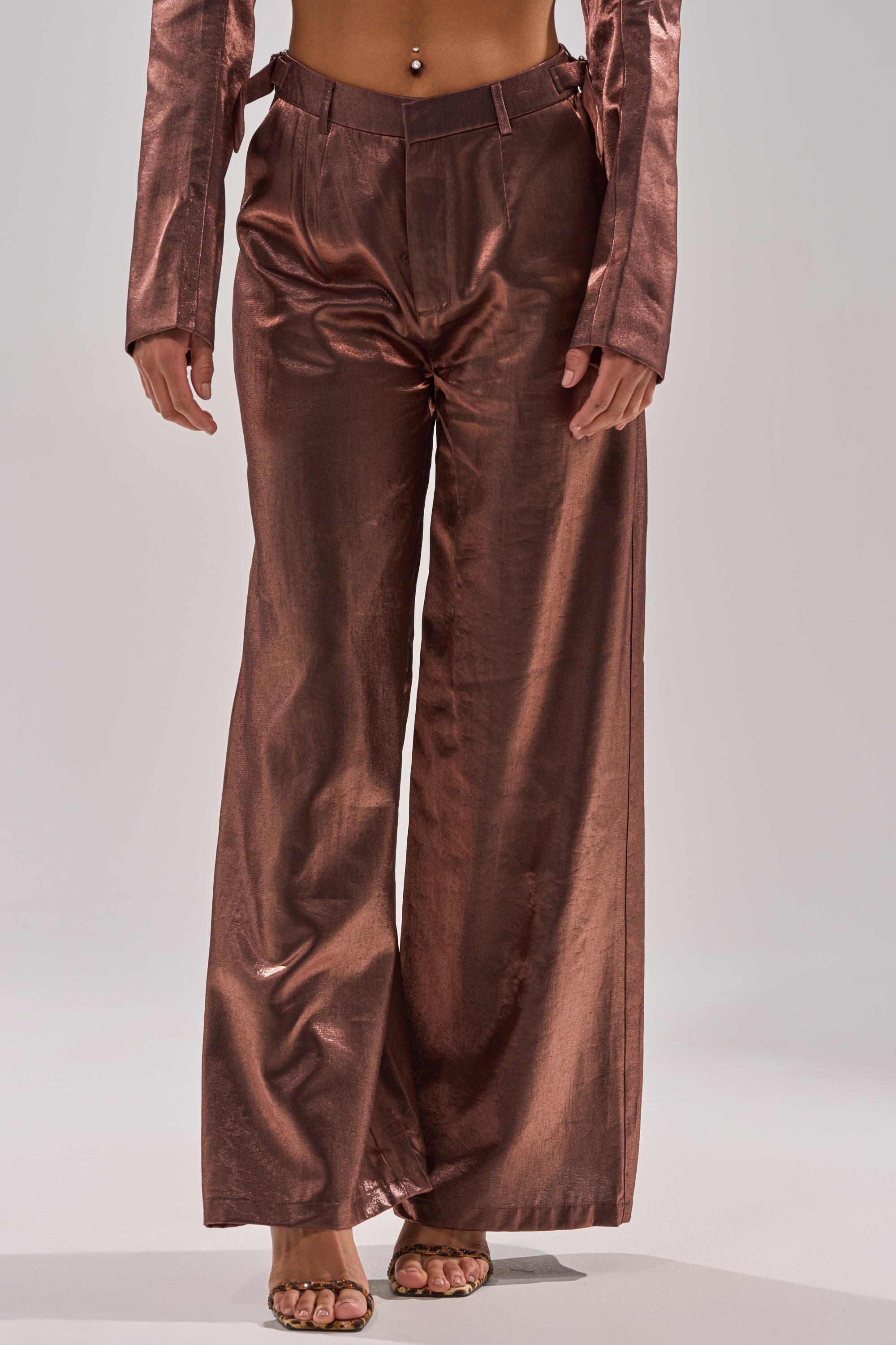A person wears the STAY CLOSE IRIDESCENT TROUSER, high-waisted and wide-leg, paired with a matching long-sleeve top, standing with hands by their sides against a plain light background. 2