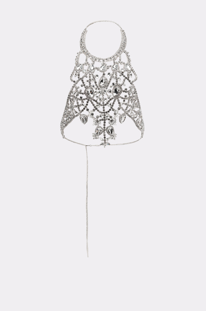 The IN YOUR DREAMS BODY CHAIN is a silver, ornate necklace featuring intricate patterns and dangling crystal-like accents, shown on a plain light background—ideal as statement jewelry. 3