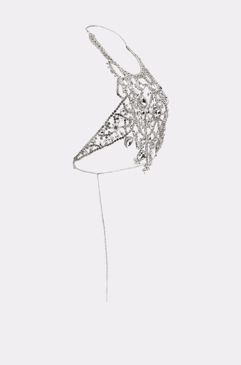 The IN YOUR DREAMS BODY CHAIN features a delicate, asymmetrical silver bikini top with rhinestones and filigree patterns, paired with a crystal body chain and thin straps in an ornate, sculptural design on a plain white background. 4