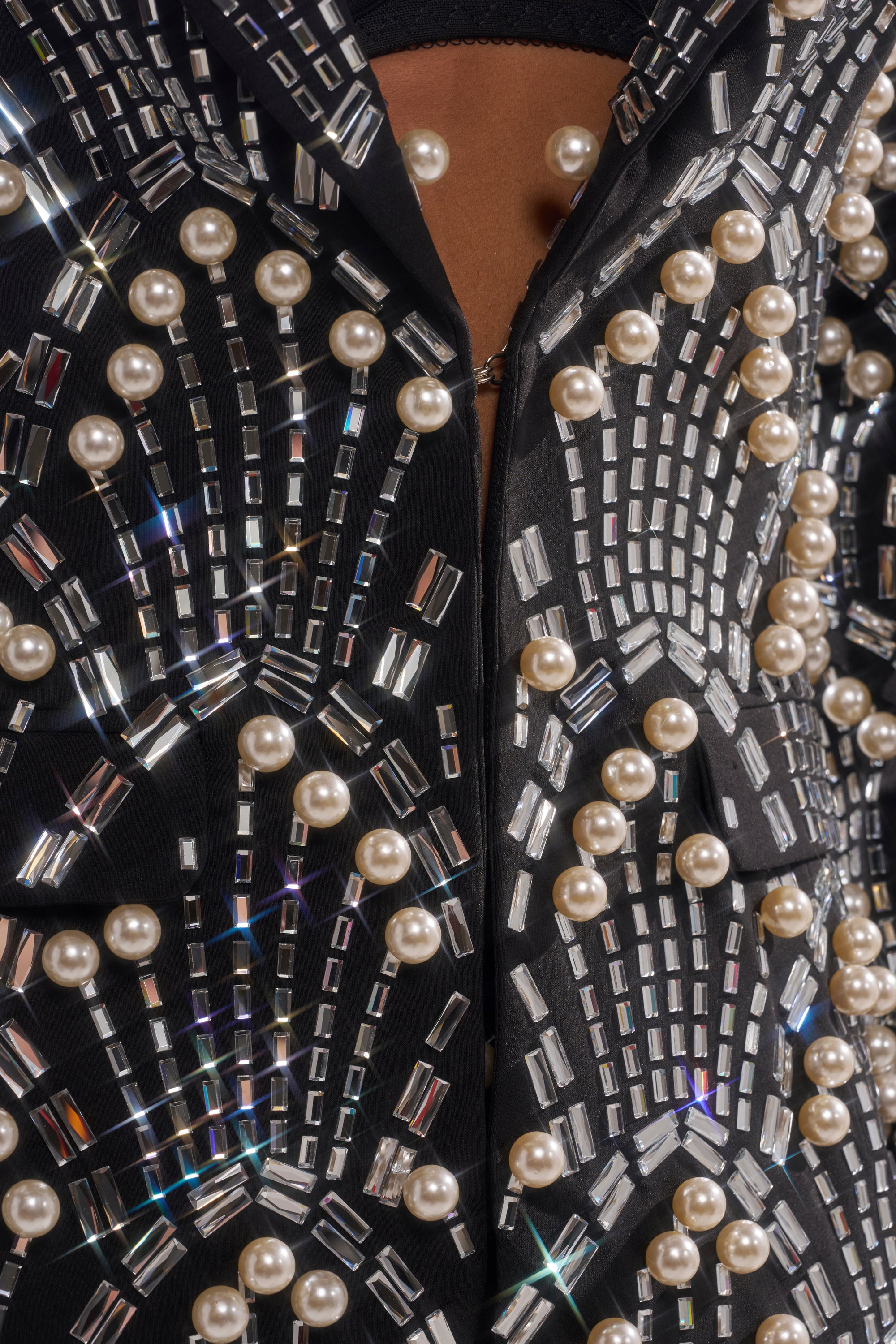 The TIMES SQUARE EMBELLISHED BLAZER features black fabric decorated with shiny rectangular beads and round pearls in geometric patterns for a luxurious, textured look.