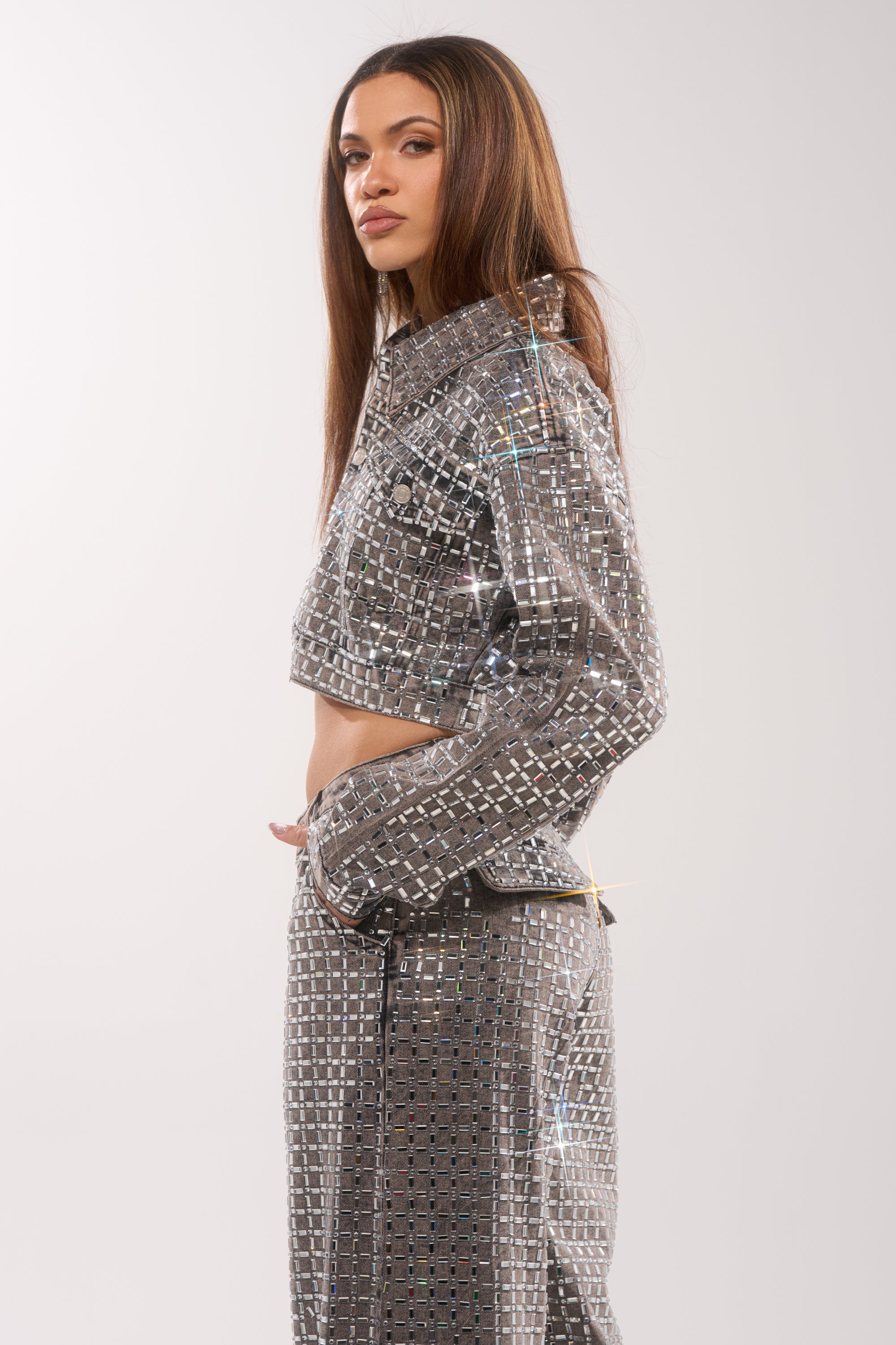 A woman with long straight hair models the PICK N CHOOSE RHINESTONE DENIM JACKET IN GREY, posing in profile against a plain light background. 5
