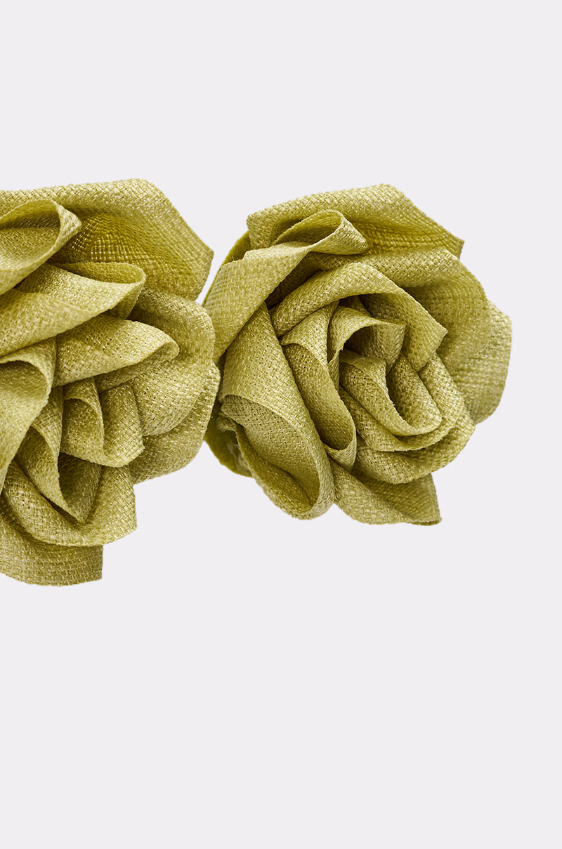 The AT BRUNCH EARRING features two textured, light green woven fabric earrings with layered petals, set against a plain white background for a unique statement stud look. 5