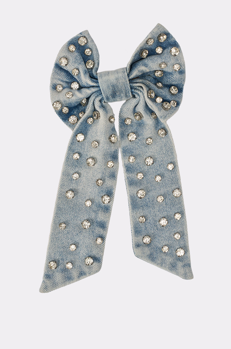 The DENIM AND DIAMONDS HAIR BOW is a rhinestone denim hair clip with an oversized bow and two long tails, adorned with shiny silver rhinestones, displayed on a plain white background. 5