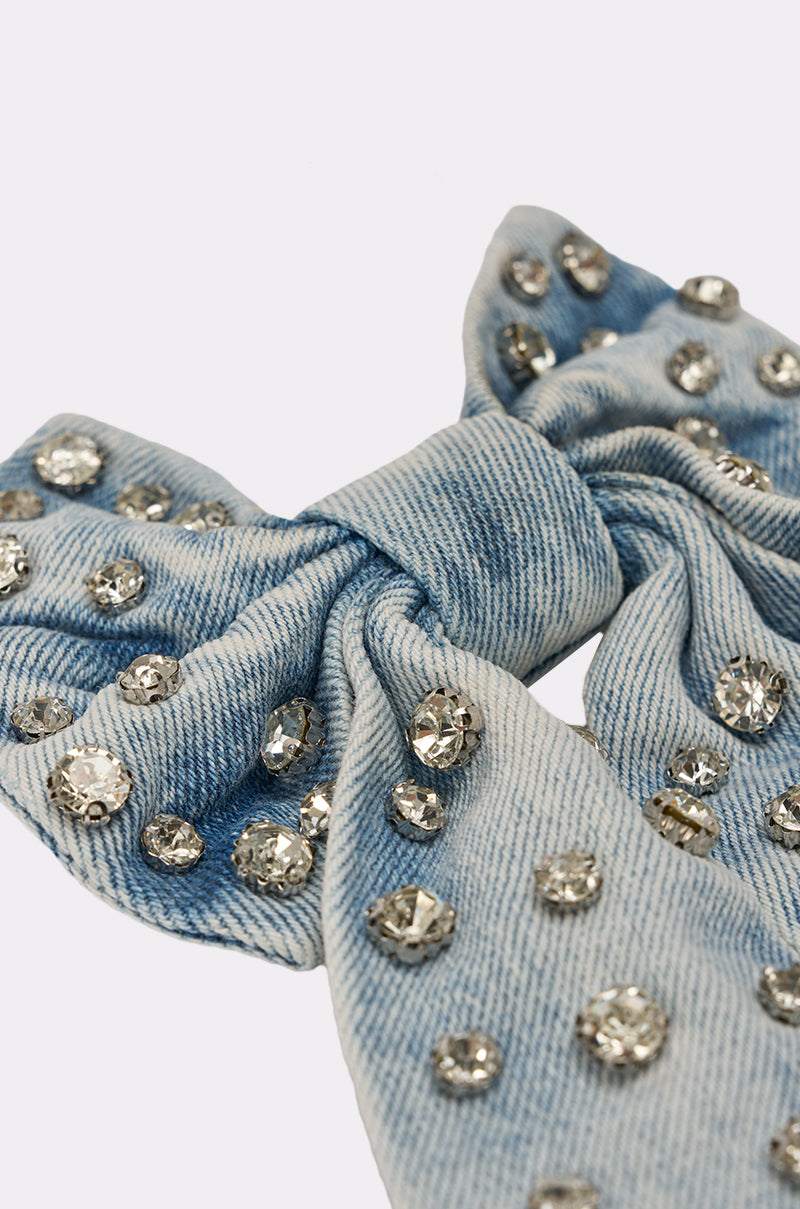 The DENIM AND DIAMONDS HAIR BOW features a denim bow decorated with clustered sparkling rhinestones, set against a plain light background. 6