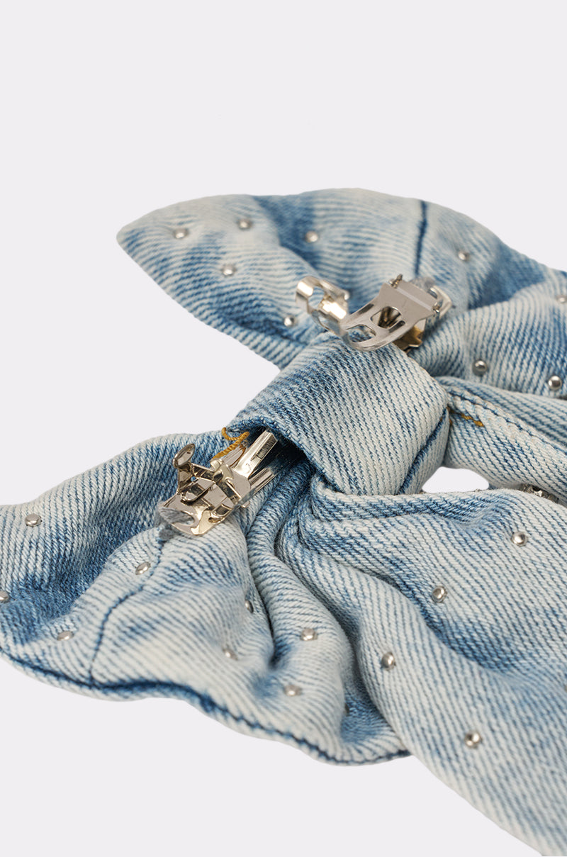 The DENIM AND DIAMONDS HAIR BOW features light blue denim with small silver studs and a shiny silver embellished hair clip, shown close-up against a plain white background. 7
