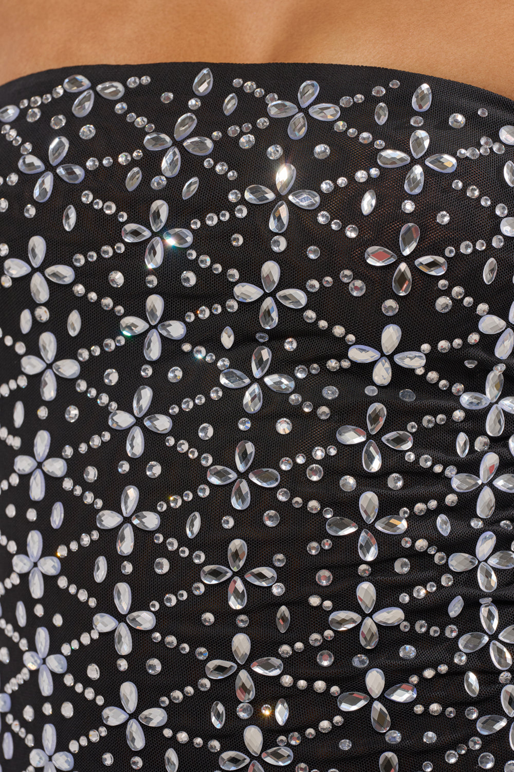 Close-up of the MORE THE MERRIER EMBELLISHED MAXI DRESS featuring strapless black fabric, detailed with silver and clear rhinestones arranged in striking geometric patterns. 7