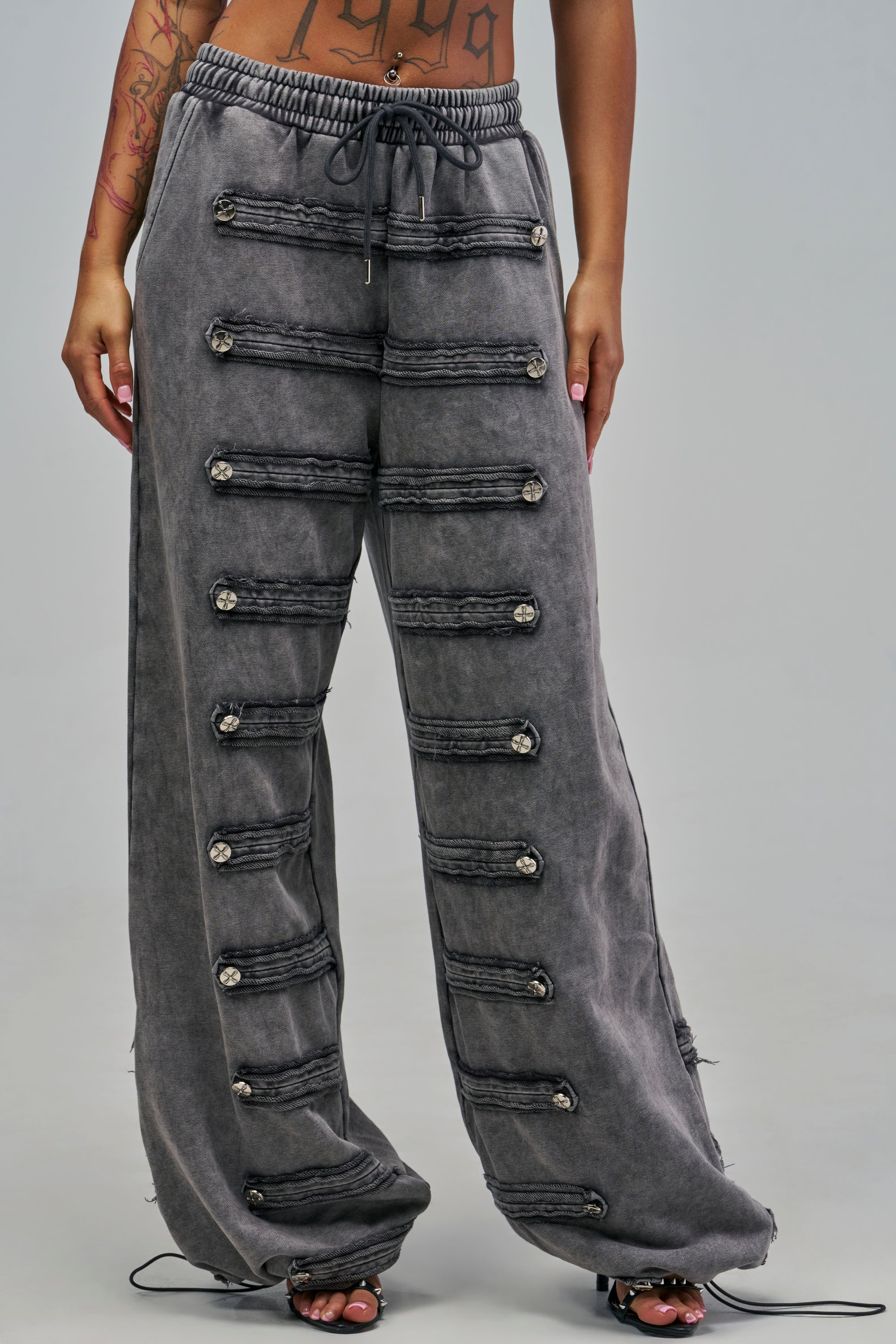 MEET ME AT THE TOP MINERAL WASH SWEATPANT in charcoal grey with a wide-leg silhouette, a drawstring waist, and two vertical rows of decorative buttons along the front.