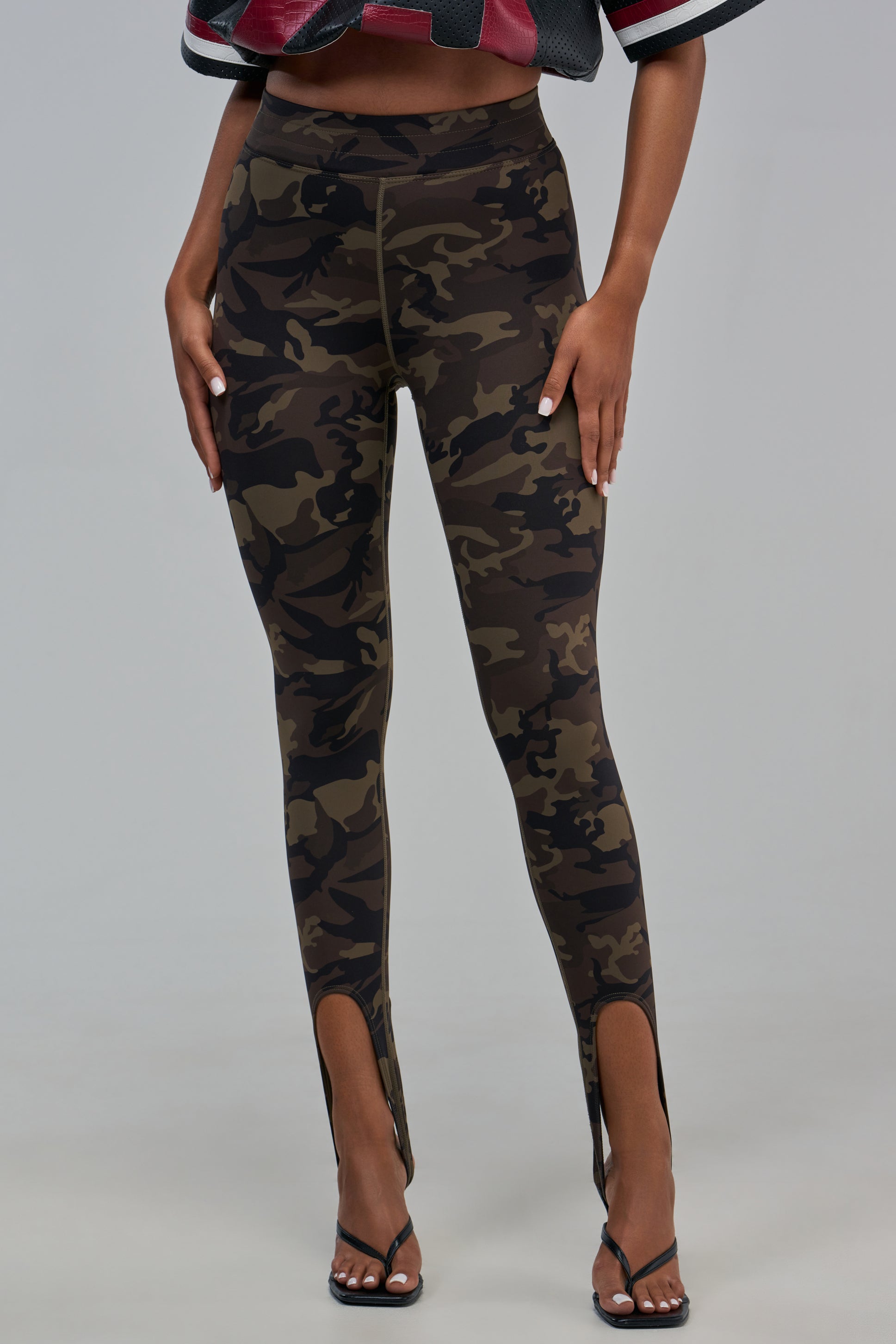 CAMO STIRRUP LEGGING high-waisted green camo print leggings with stirrup cuffs.