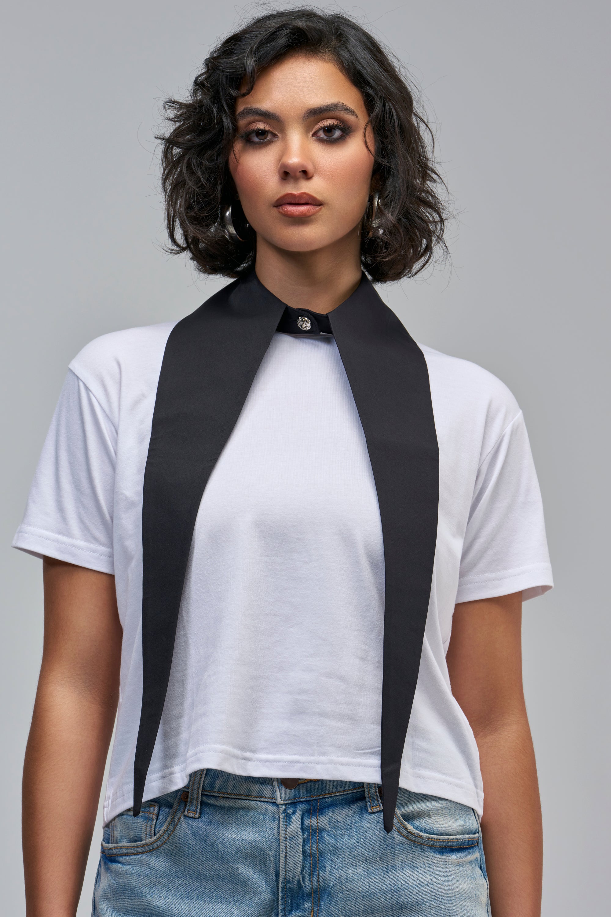 A person wears a DOUBLE DAGGER COLLAR IN BLACK, featuring long pointed ends over a white t-shirt for an office siren look.