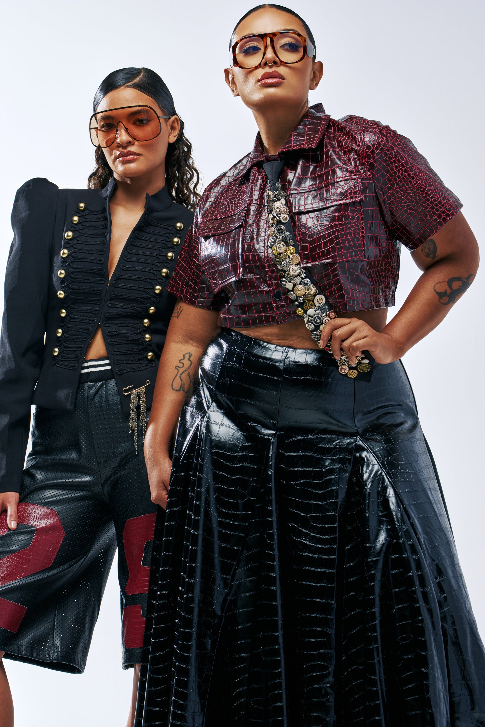 Two models posing, one wearing a PUSHING MY BUTTONS TIE made of various mismatched buttons.