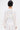 A person with short dark hair is seen from behind wearing the COVER UP CHIFFON SHRUG, a loose, long-sleeved white blouse ideal for layering on special occasions, paired with white high-waisted pants against a plain light background.