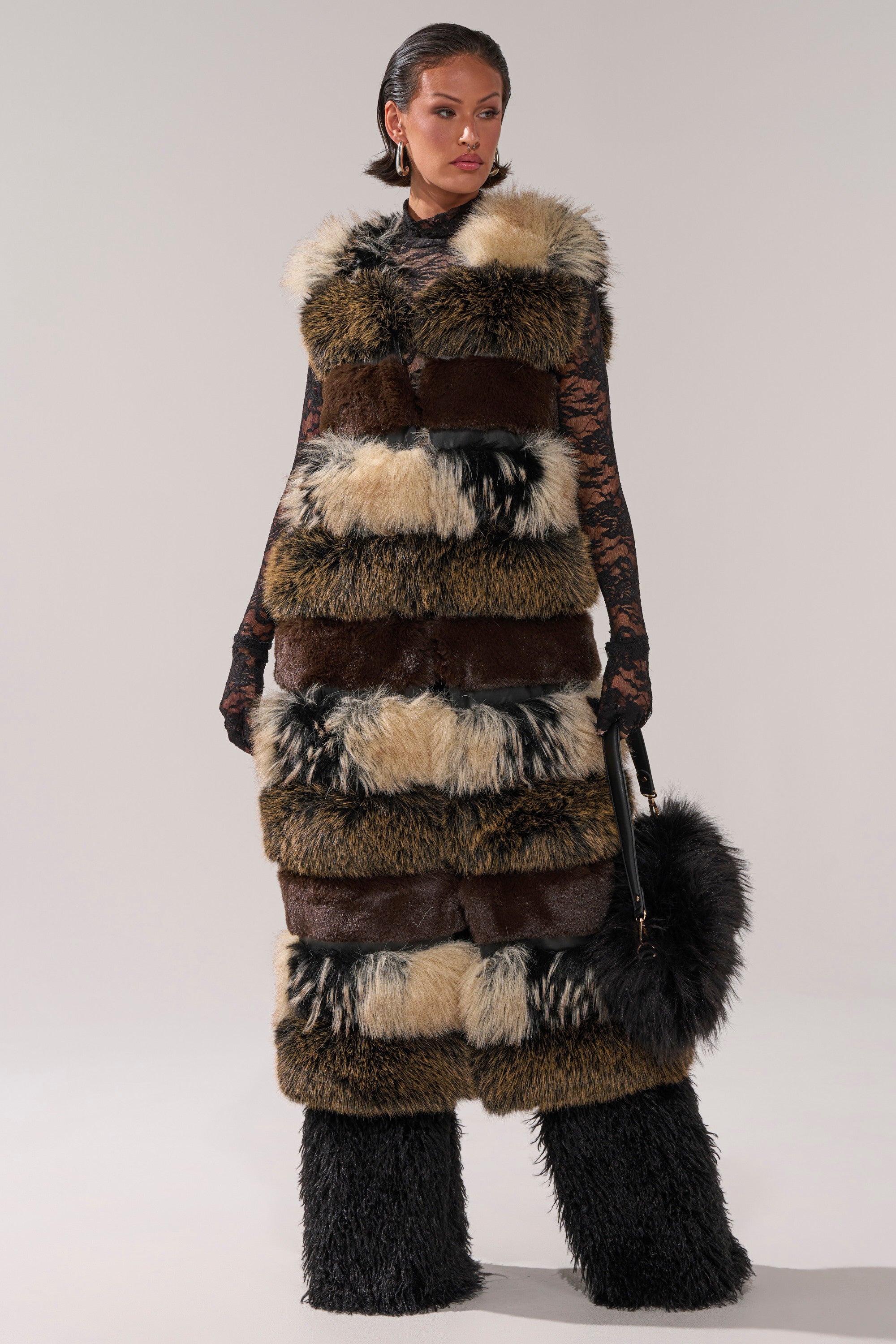A woman wearing the PORTIA PANELED FUR VEST exudes modern elegance.