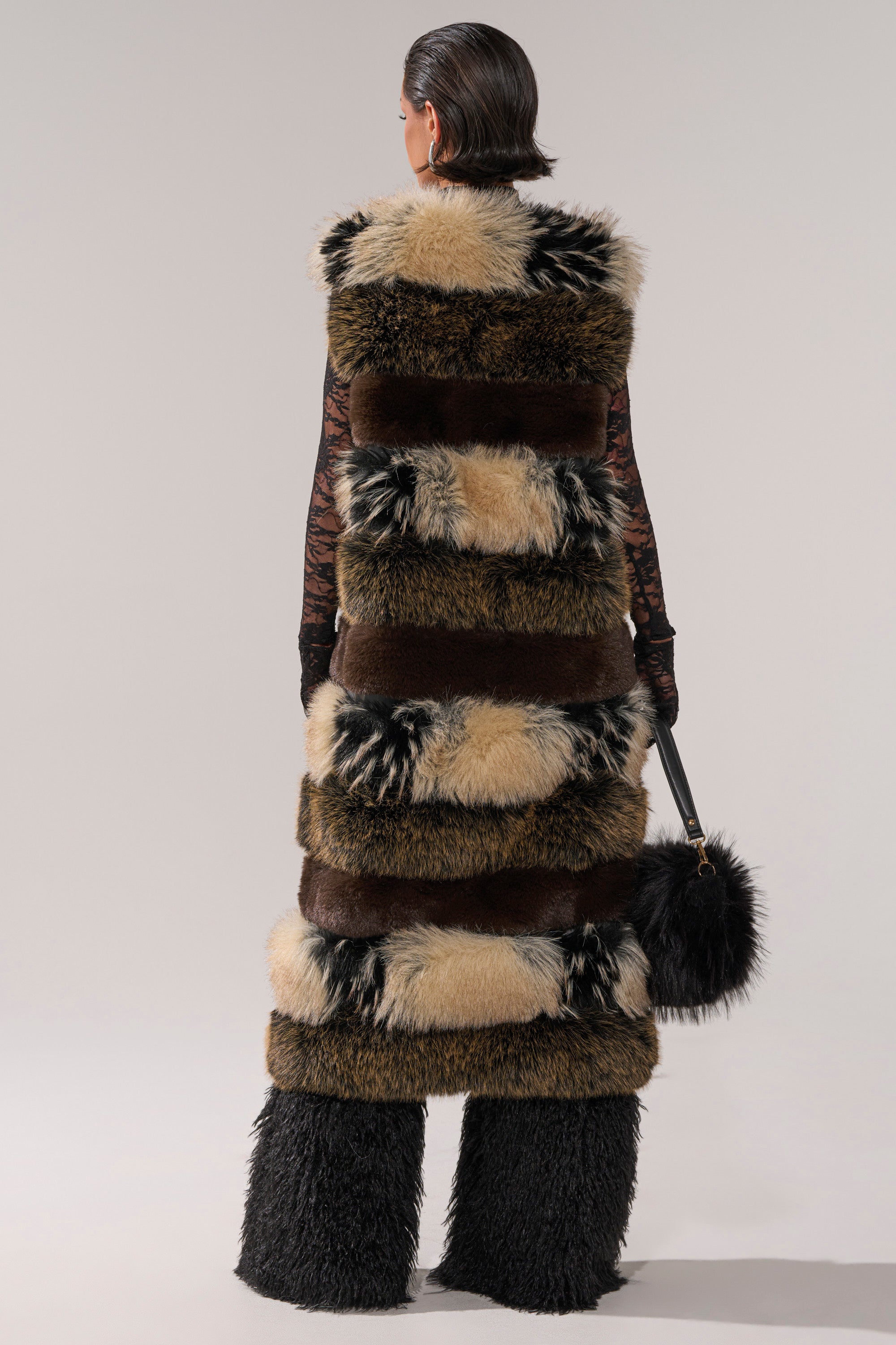 A woman wears the stylish PORTIA PANELED FUR VEST.