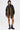 A woman wears the MARLEY LACE UP BOMBER with colorful ribbon fringe, black sunglasses, sheer biker shorts, and chunky combat boots, standing against a plain white background.