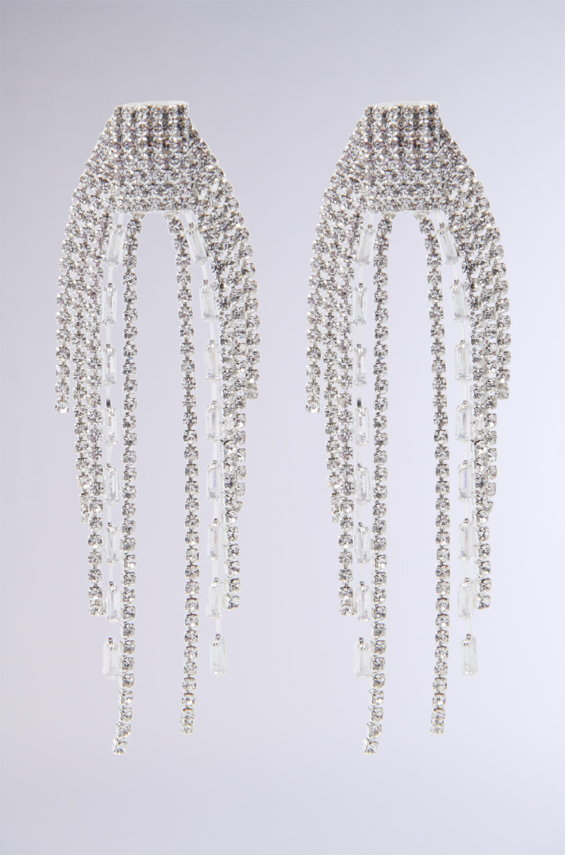 Experience the INTO THE NIGHT BLING EARRING, featuring a sophisticated silver arrangement with geometric cascading strands embellished with dazzling rhinestones, beautifully highlighted against a simple gray backdrop.