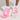 A person dons the GIRLY POP LACE RUFFLE SOCKS IN WHITE, paired with fluffy platform slippers showcasing a vibrant mix of pink, white, and light blue hues against a simple light backdrop—a perfect fusion of whimsy and style.