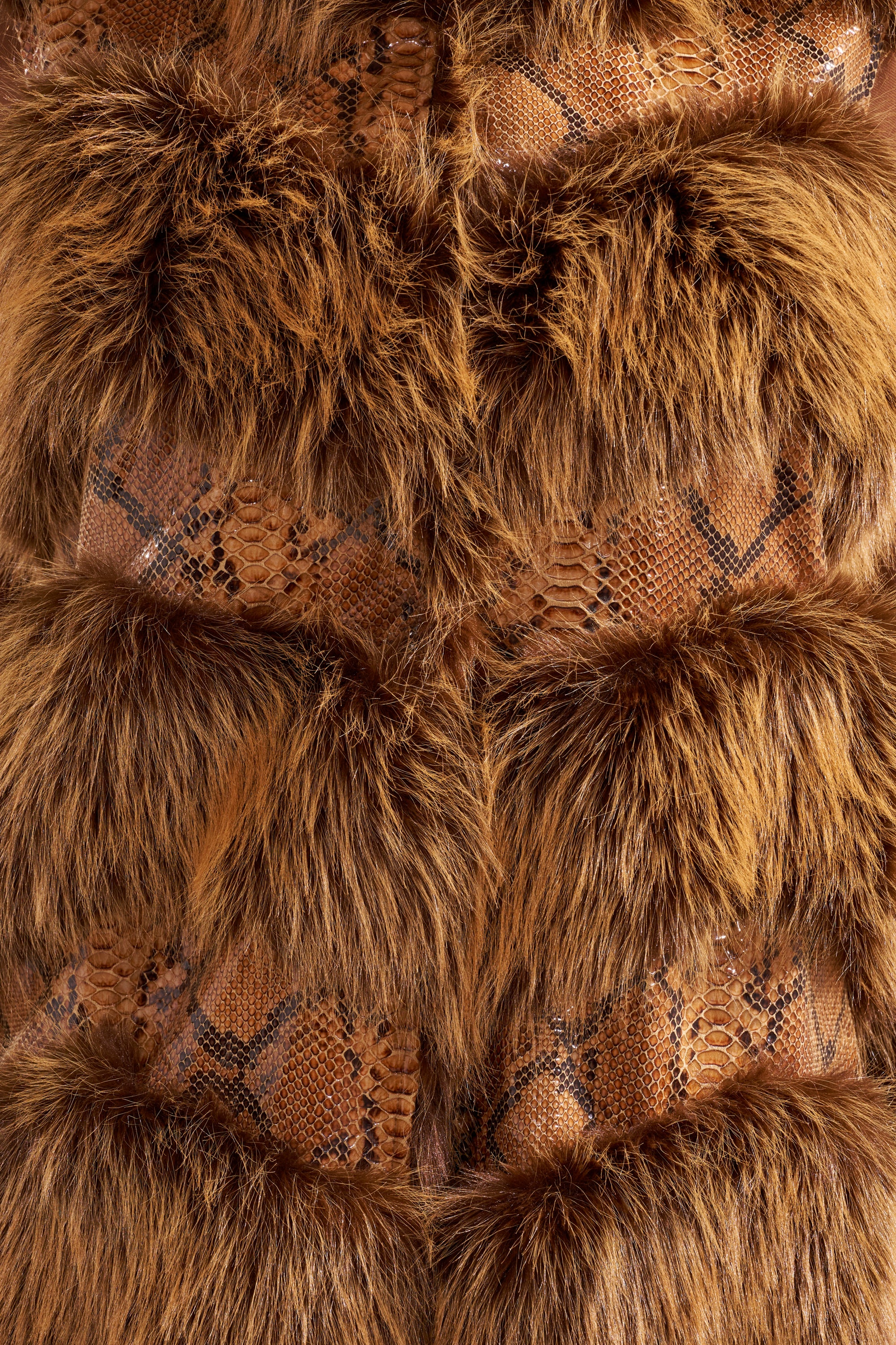 Close-up of the GOOD OMEN FUR TRIM VEST, showcasing its textured surface with alternating bands of brown faux fur and brown snakeskin print for a visually rich, layered look. 10