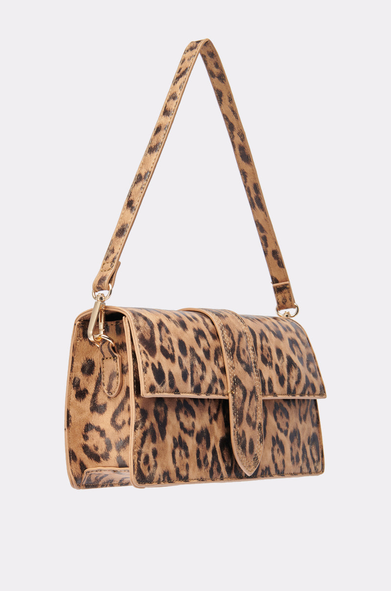 The CAN'T BE TAMED LEOPARD PRINT PURSE is a stylish shoulder bag with a brown and black leopard print pattern on its exterior and a short strap, set against a plain white background.