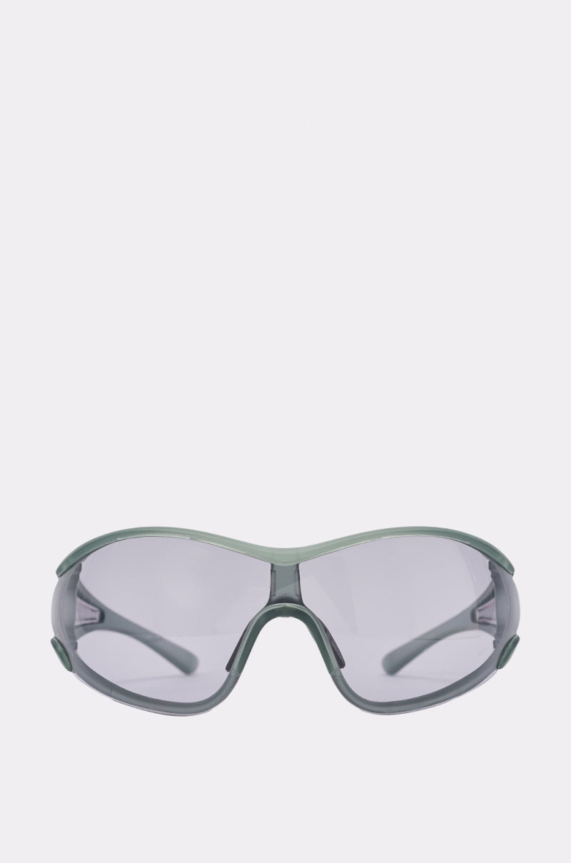 TRY TO KEEP UP SUNGLASSES with clear, slightly tinted lenses and a wraparound design, reminiscent of translucent grey shield sunglasses, displayed on a plain white background.